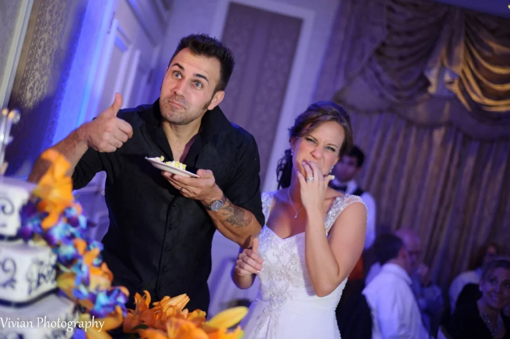 bride-and-groom-eating-cake-making-funny-faces.png
