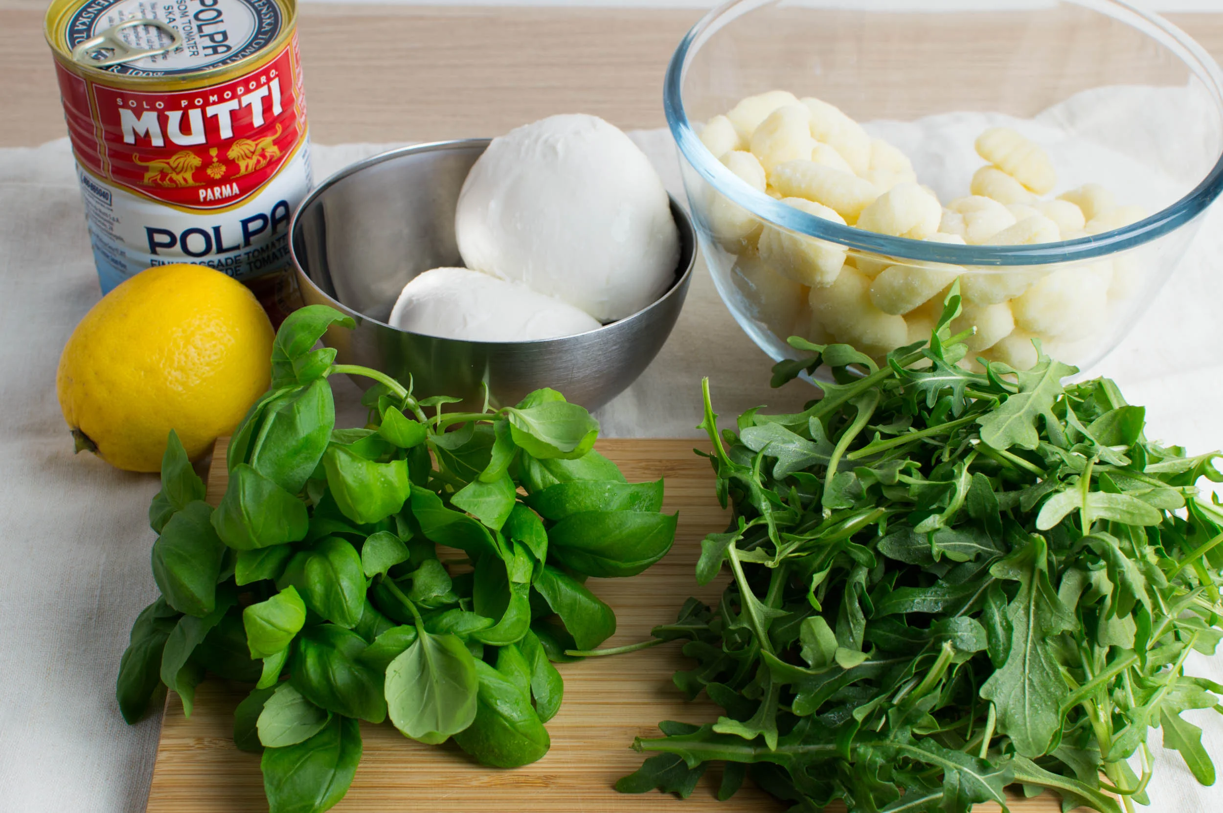 Krossade tomater, mozzarella, gnocchi, citron, basilika och rucola