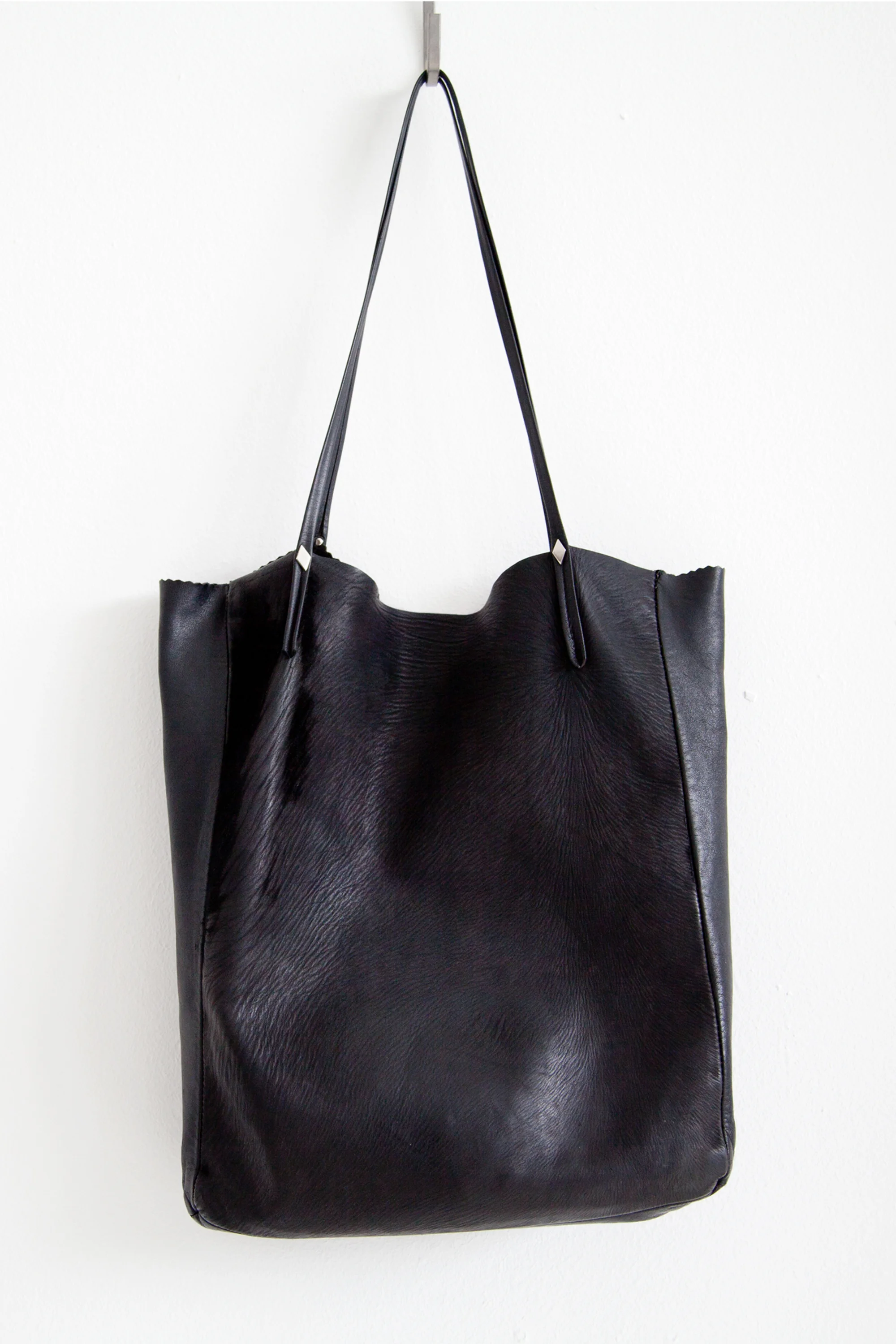 Black Leather Tote BagThis bag has been accompanying me since 2013 (this is what it looks like now.  The straps may be thin, but they surely are stronger then they look, the usual contents of my bag are a laptop, a good book, my calender planer…