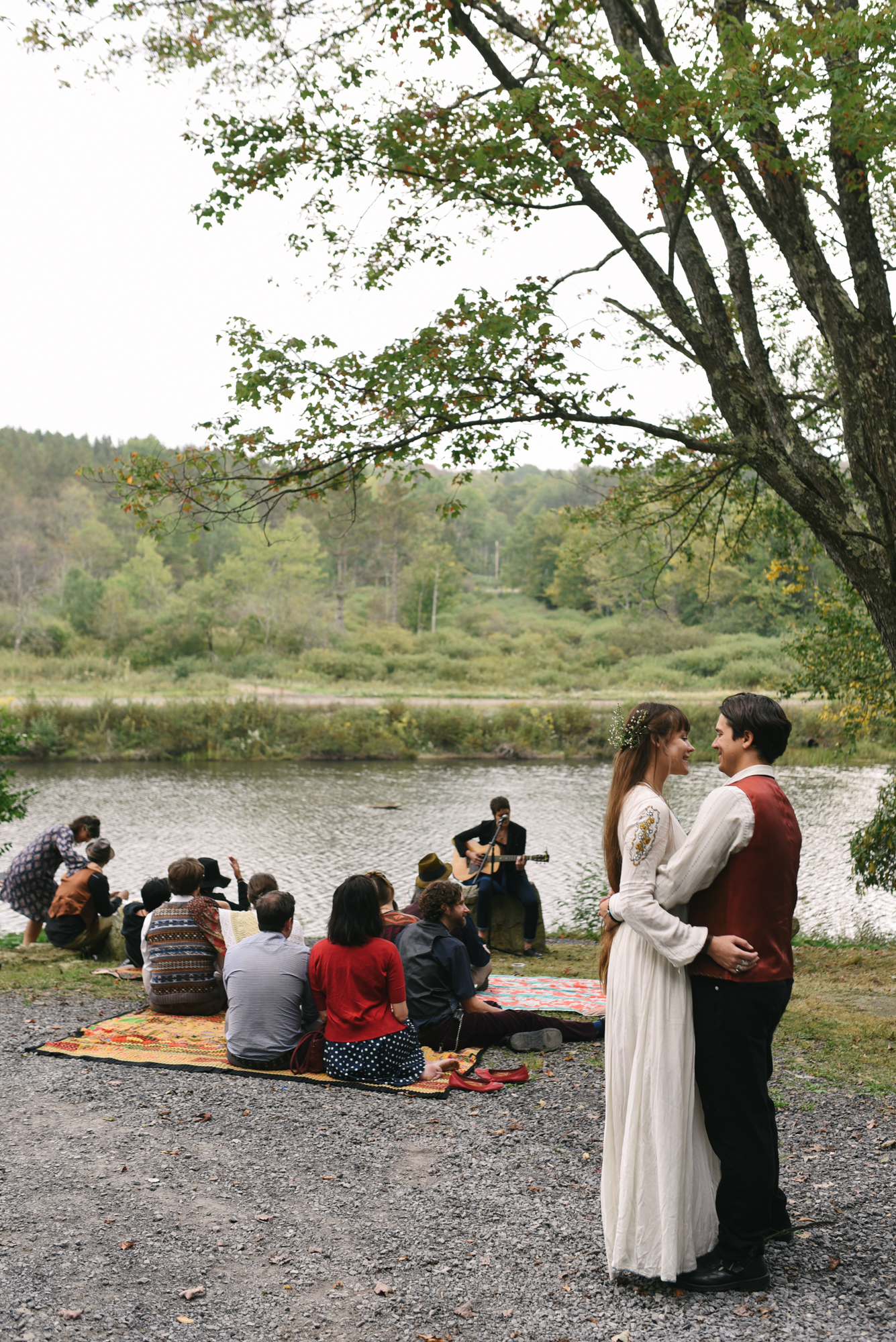  Mountain Wedding, Outdoors, Rustic, West Virginia, Maryland Wedding Photographer, DIY, Casual, bride and groom hugging and laughing with friend plays guitar 