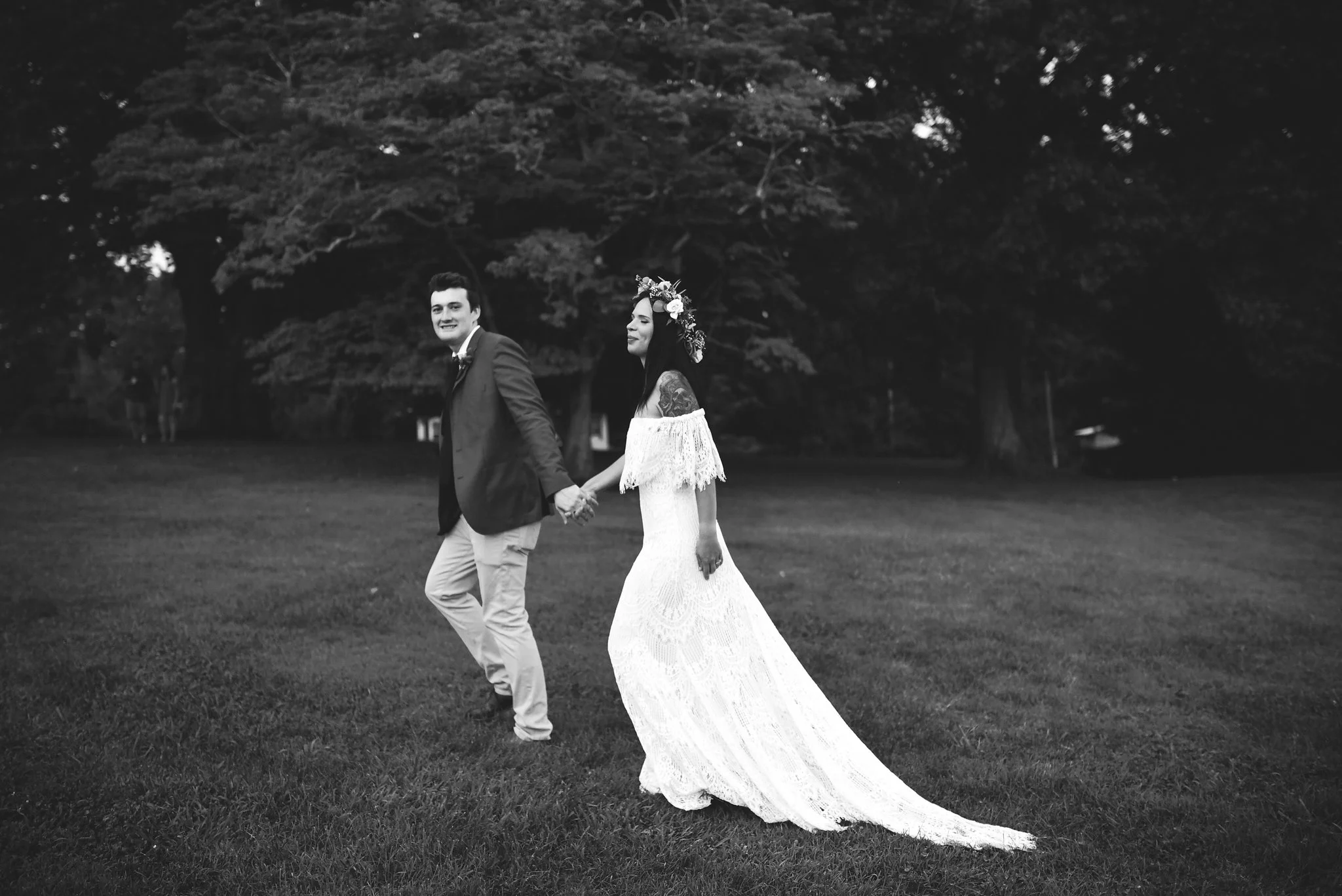 Maryland, Eastern Shore, Baltimore Wedding Photographer, Romantic, Boho, Backyard Wedding, Nature, Black and White Photo, Bride and Groom Holding Hands and Walking Through Field, Outdoor Reception, Daughters of Simone Wedding Dress
