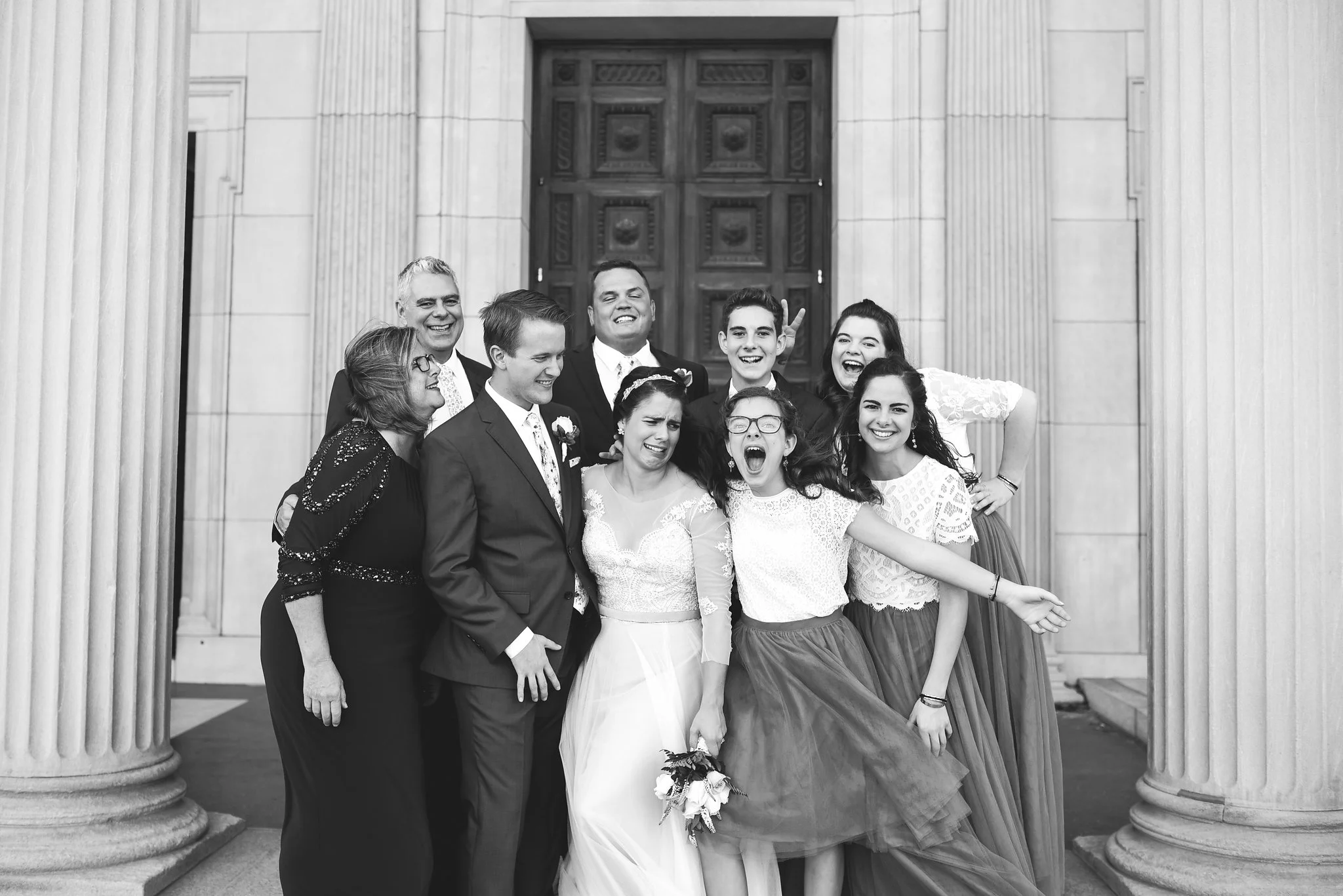 Baltimore, Canton, Church Wedding, Modern, Outdoors, Maryland Wedding Photographer, Romantic, Classic, St. Casimir Church, Silly portrait of bride and groom with family, black and white photo, lace bridesmaid dresses