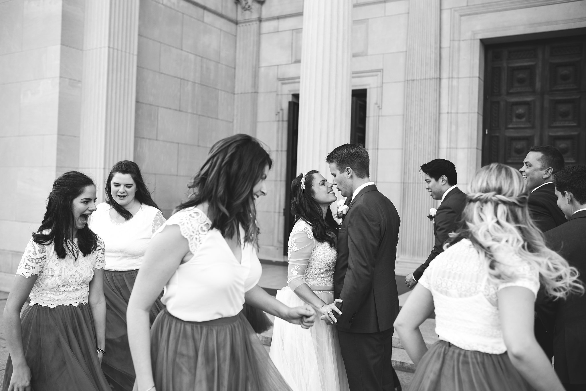  Baltimore, Canton, Church Wedding, Modern, Outdoors, Maryland Wedding Photographer, Romantic, Classic, St. Casimir Church, Bride and groom holding each other and smiling while encircled by wedding party, black and white photo 