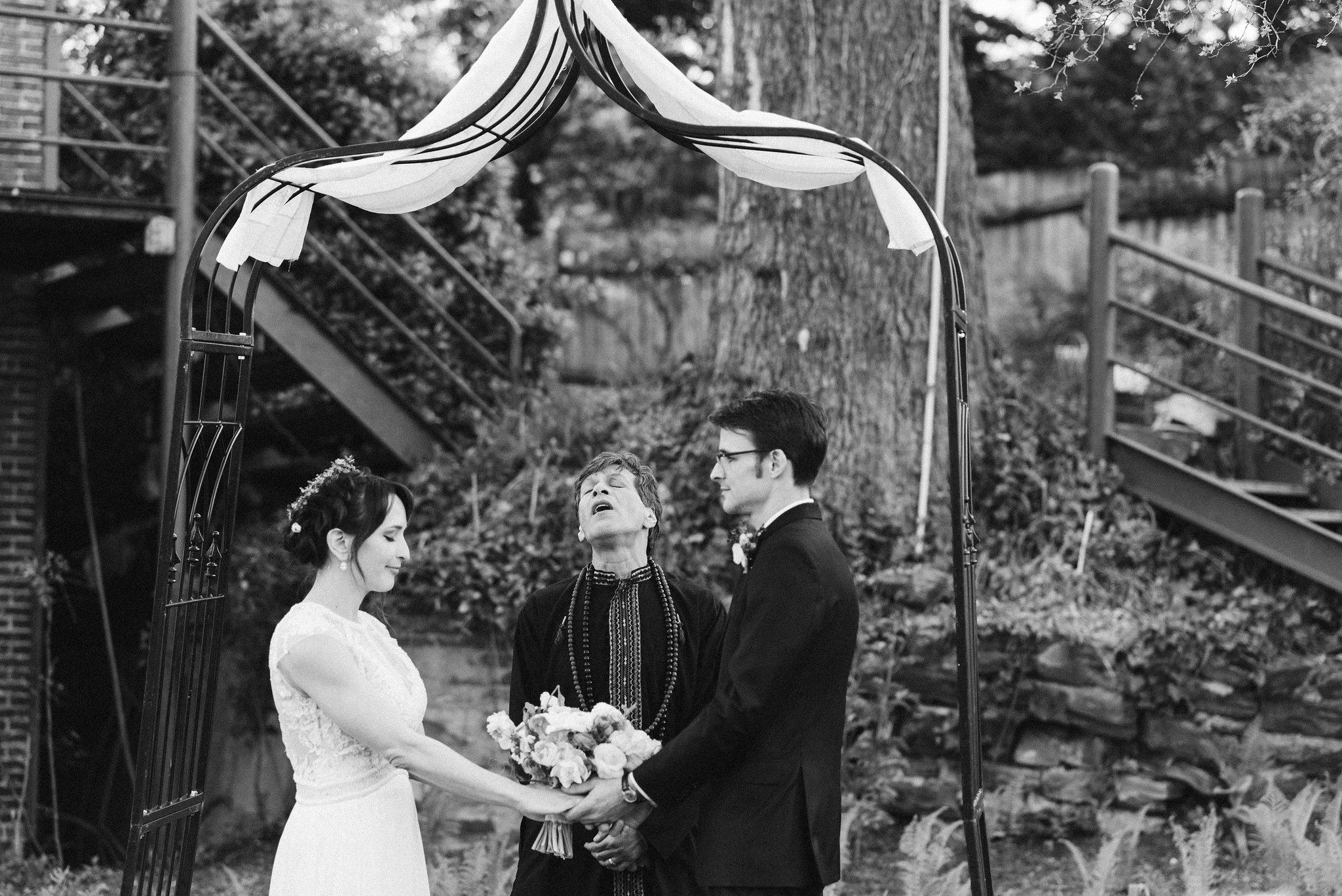  Baltimore, Maryland Wedding Photographer, Hampden, Eco-Friendly, Green, The Elm, Simple and Classic, Vintage, Bride and Groom Holding Hands Under Archway, Black and White Photo 