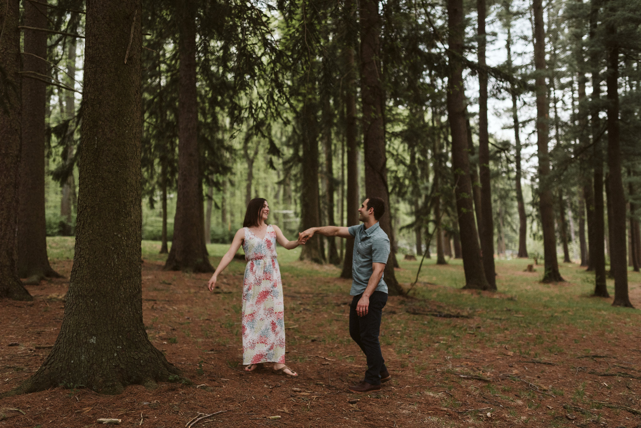 bride and groom dancing and twirling in a pine forest in maryland