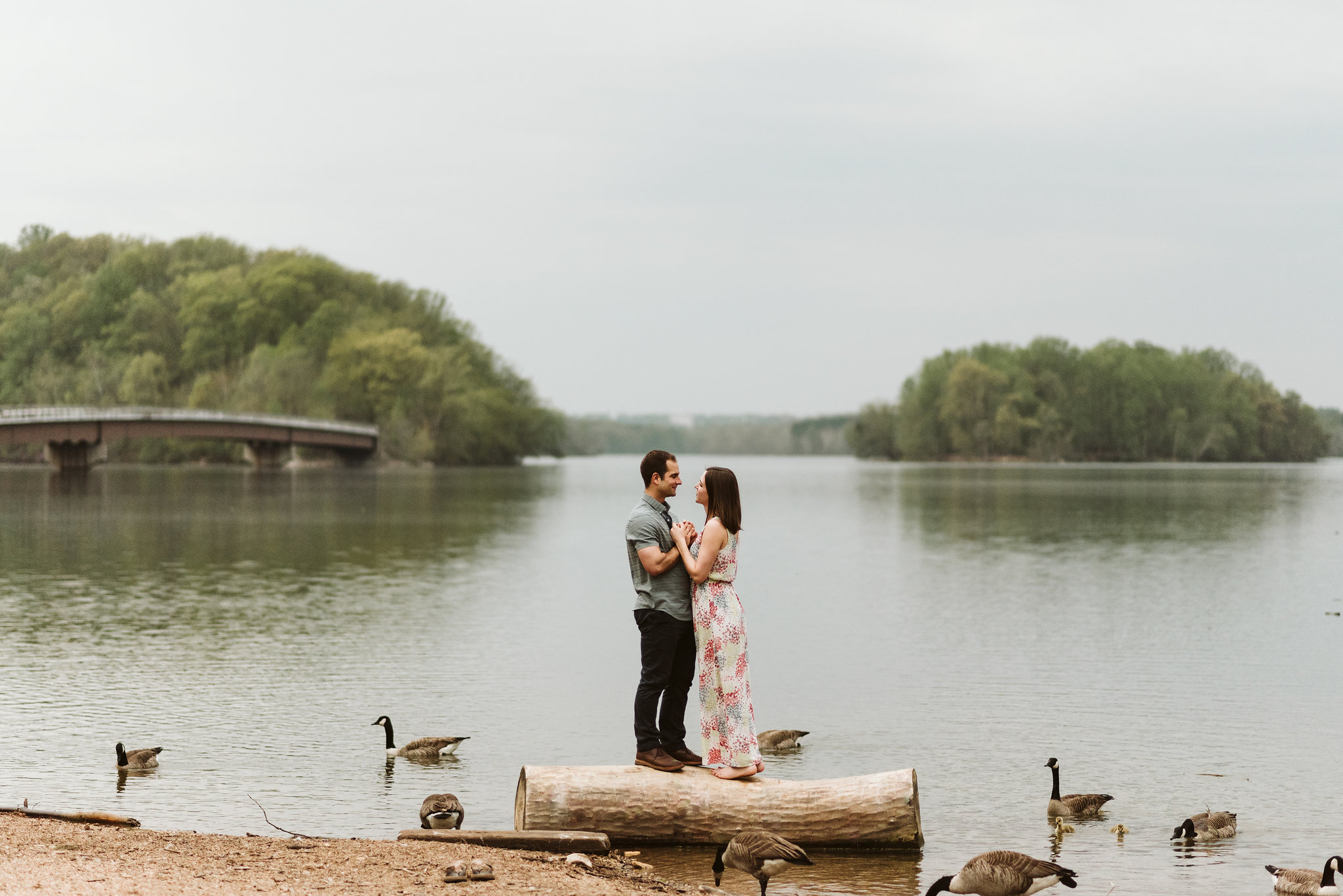 man and woman holding each other during lakefront engagement photos