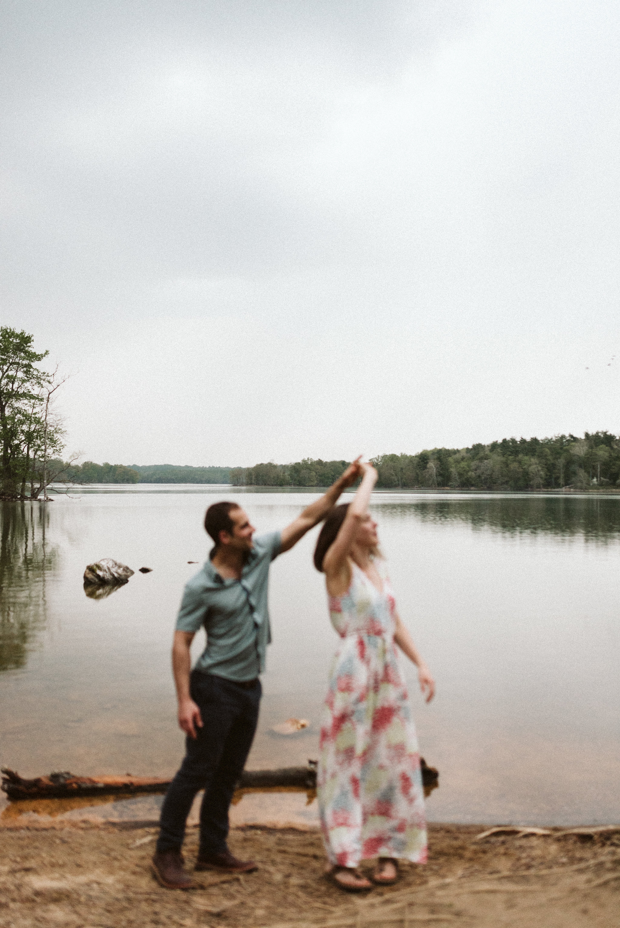 man twirling woman on shore of lake in baltimore