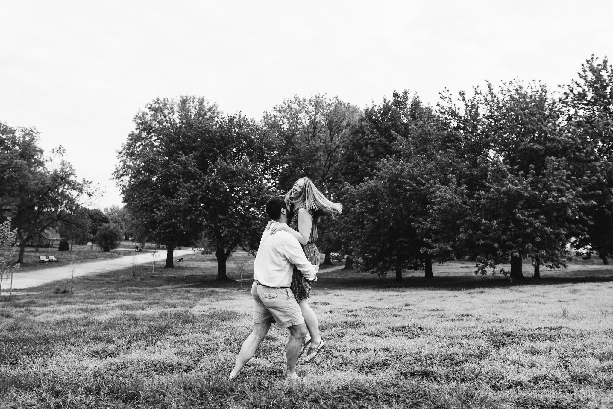 Engagement Photos, Patterson Park, Baltimore, Maryland Wedding Photographer, Casual, Fun, Nature, Groom Picking Up Bride and Spinning, Black and White Photo