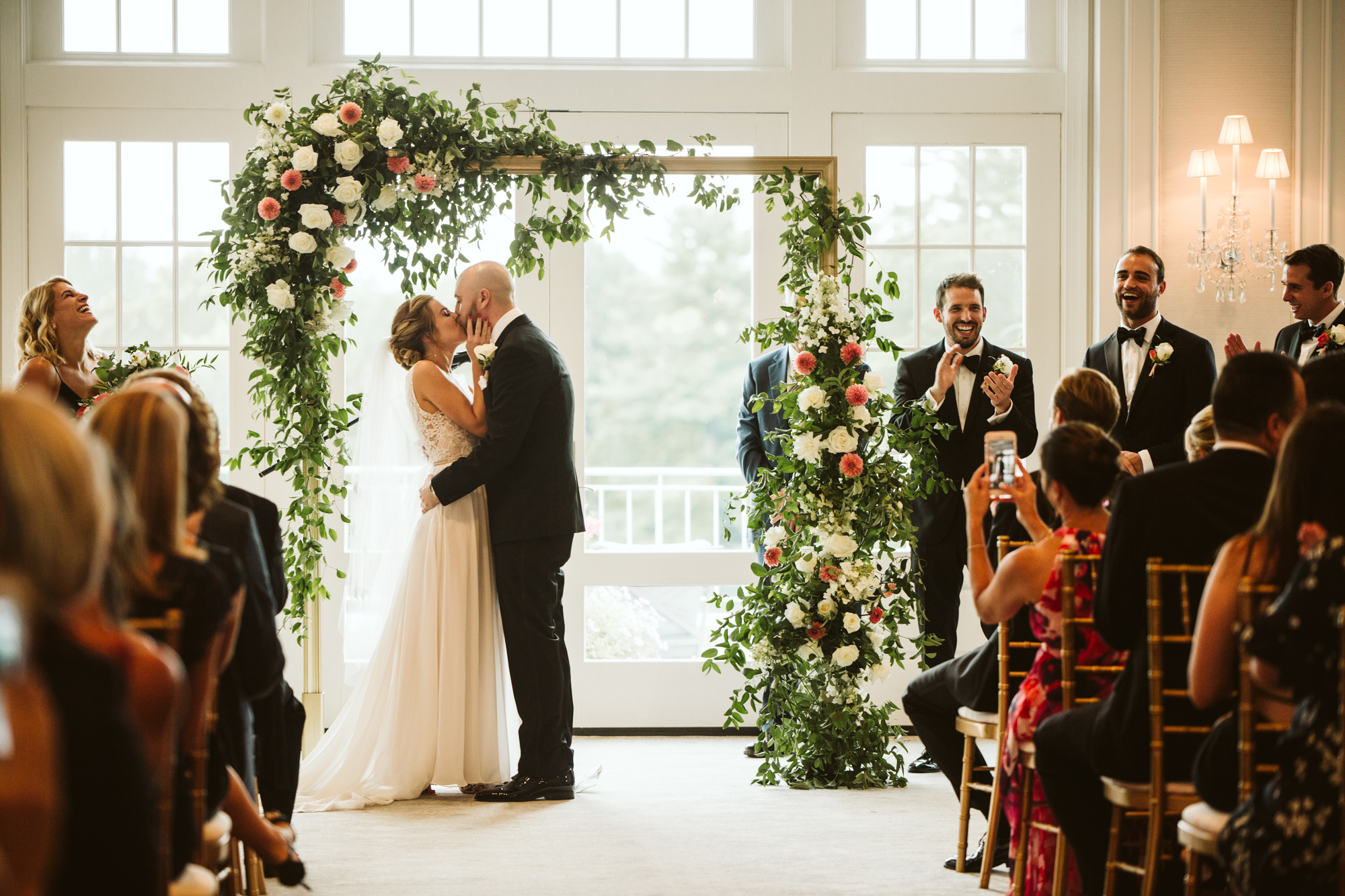 Elegant, Columbia Country Club, Chevy Chase Maryland, Baltimore Wedding Photographer, Classic, Traditional, Jewish Wedding, Bride and Groom Under Floral Archway, Meg Owen Floral Designs, First Kiss