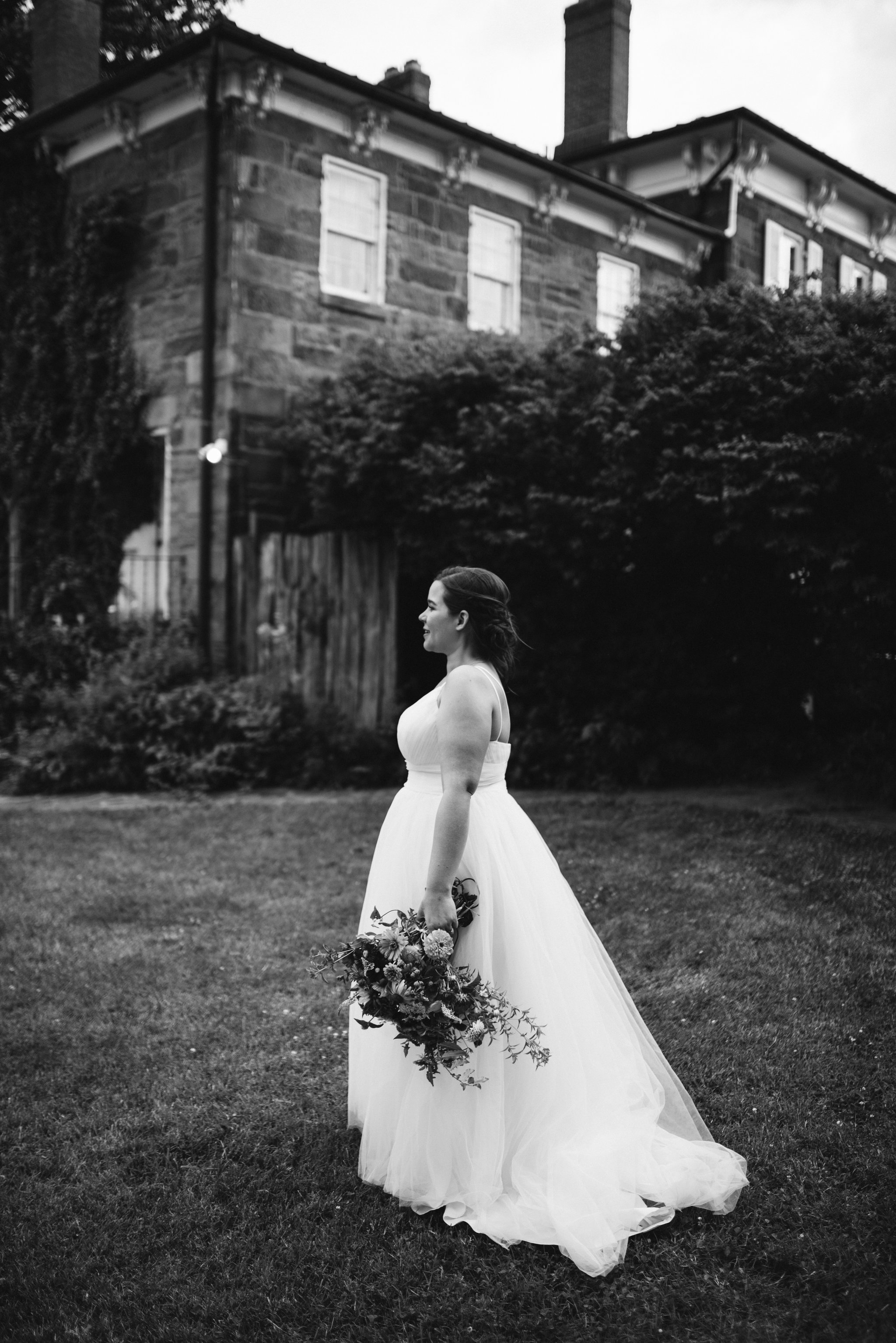 Rocklands Farm, Maryland, Intimate Wedding, Baltimore Wedding Photographer, Sungold Flower Co, Rustic, Romantic, Barn Wedding, Bride Walking Across Lawn Holding Flowers, Black and White Photo