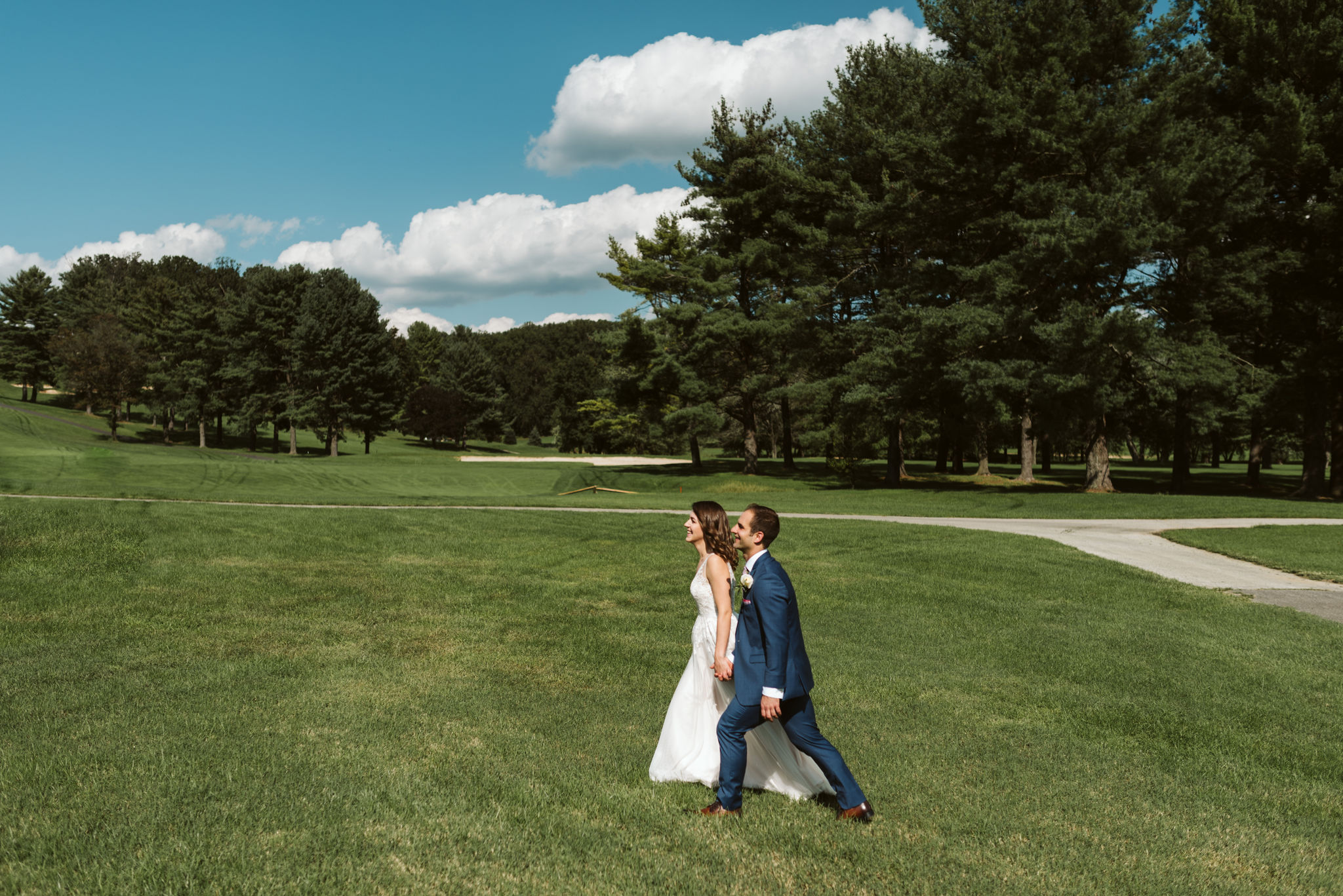  Phoenix Maryland, Baltimore Wedding Photographer, Eagle’s Nest Country Club, Classic, Romantic, Spring, Bride and Groom Walking through the Grass Hand in Hand, Blue Suit from Generation Tux 