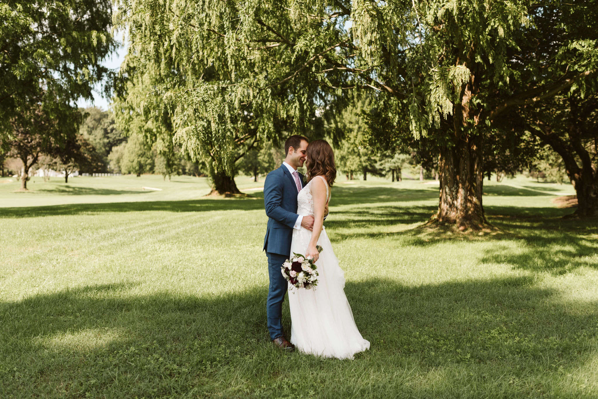  Phoenix Maryland, Baltimore Wedding Photographer, Eagle’s Nest Country Club, Classic, Romantic, Spring, Bride and Groom Kissing Under the Trees, Dundalk Florist, BHLDN Dress, Blue Generation Tux Suit 