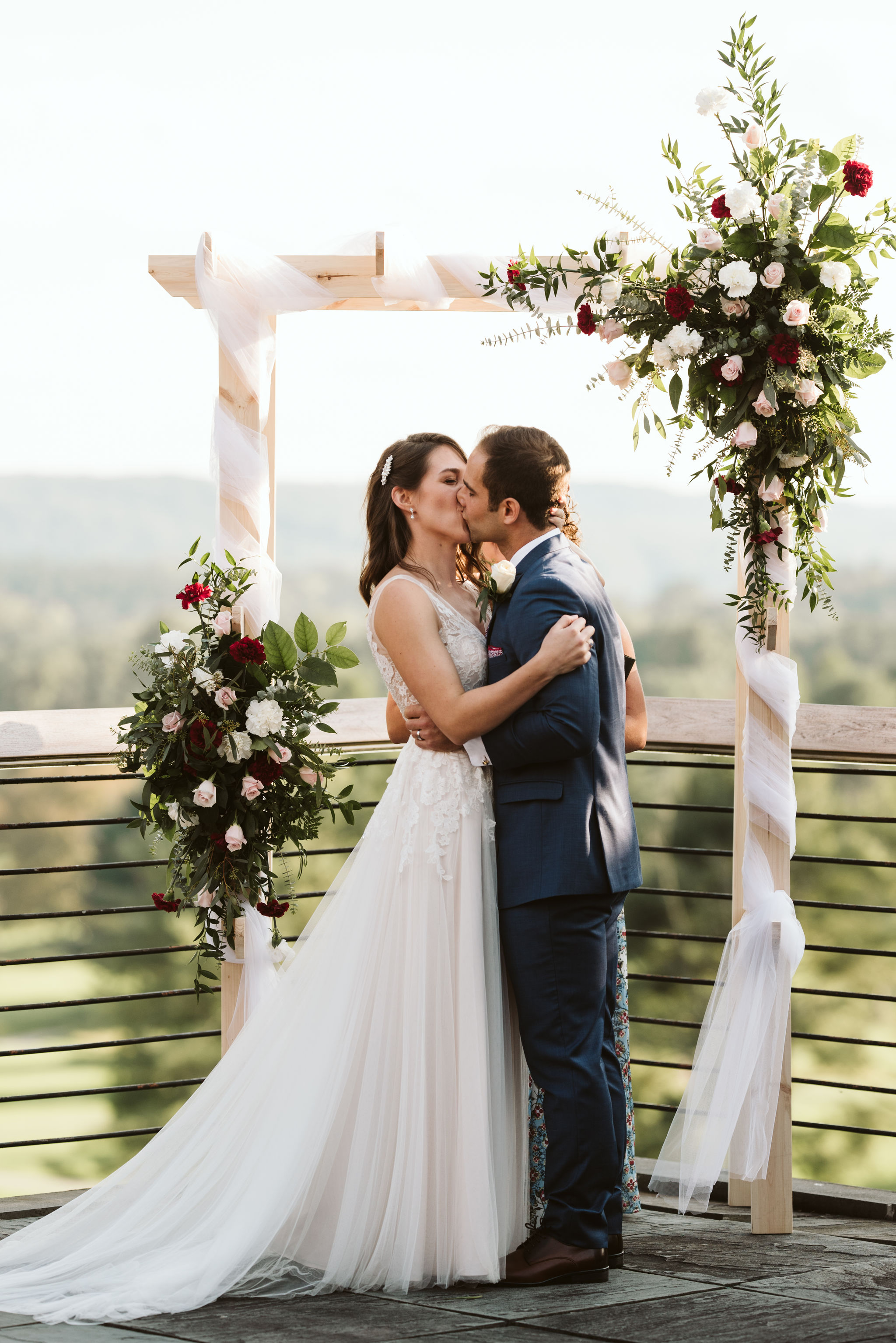  Phoenix Maryland, Baltimore Wedding Photographer, Eagle’s Nest Country Club, Classic, Romantic, Spring, Bride and Groom Share First Kiss, Just Married, Red and White Floral Arrangements, Dundalk Florist, BHLDN Dress 