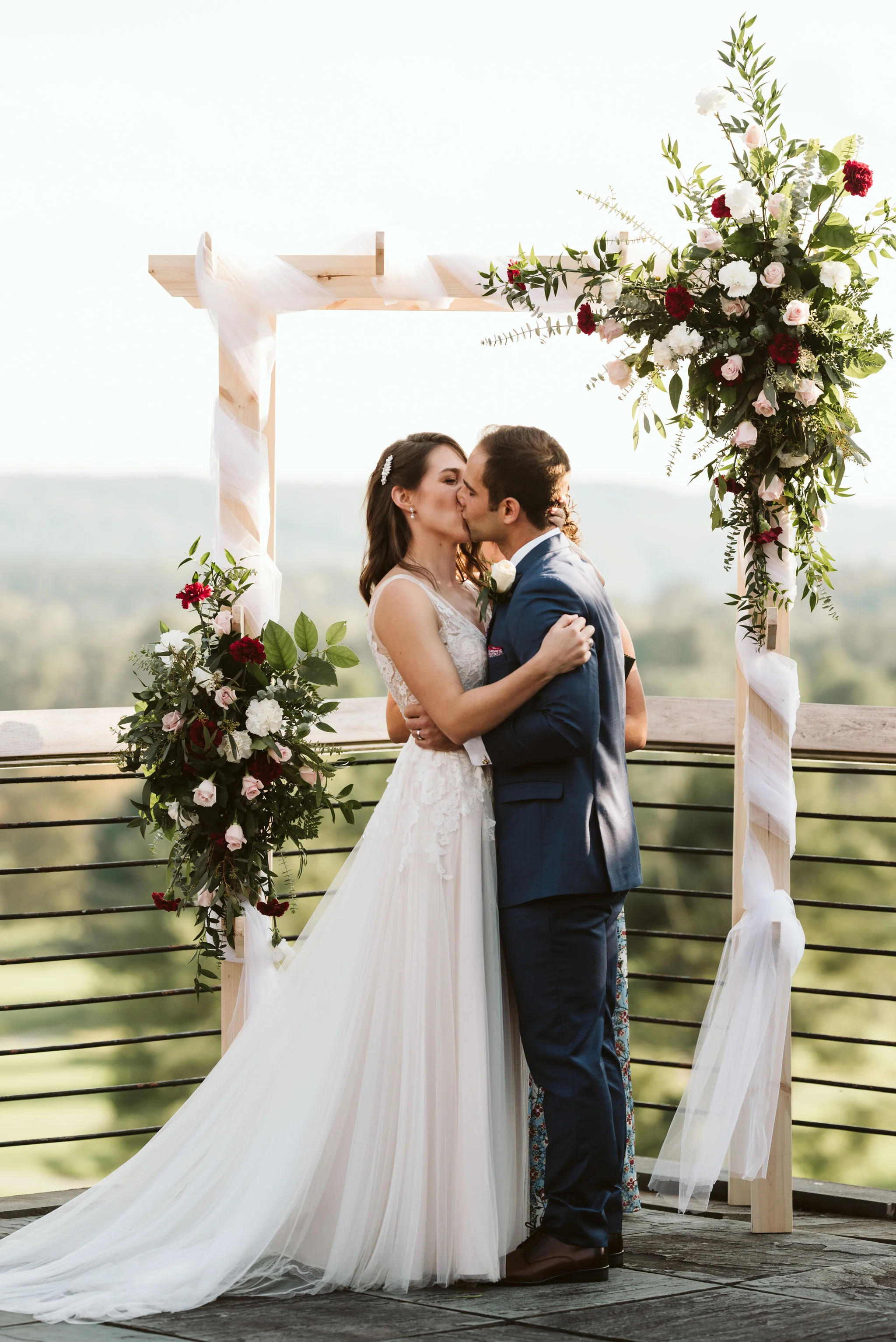 Phoenix Maryland, Baltimore Wedding Photographer, Eagle’s Nest Country Club, Classic, Romantic, Spring, Bride and Groom Share First Kiss, Just Married, Red and White Floral Arrangements, Dundalk Florist, BHLDN Dress