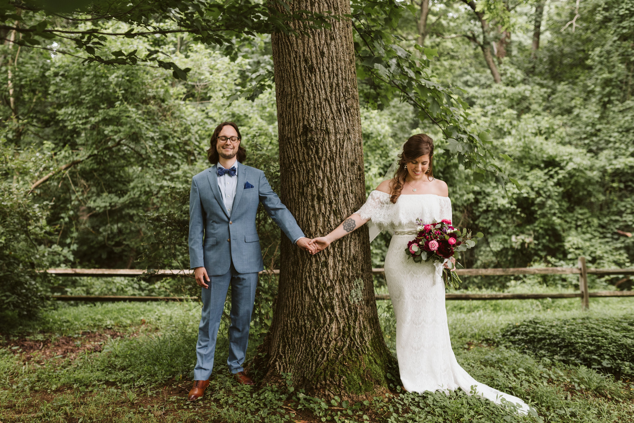 first look inspiration bride and groom holding hands around tree