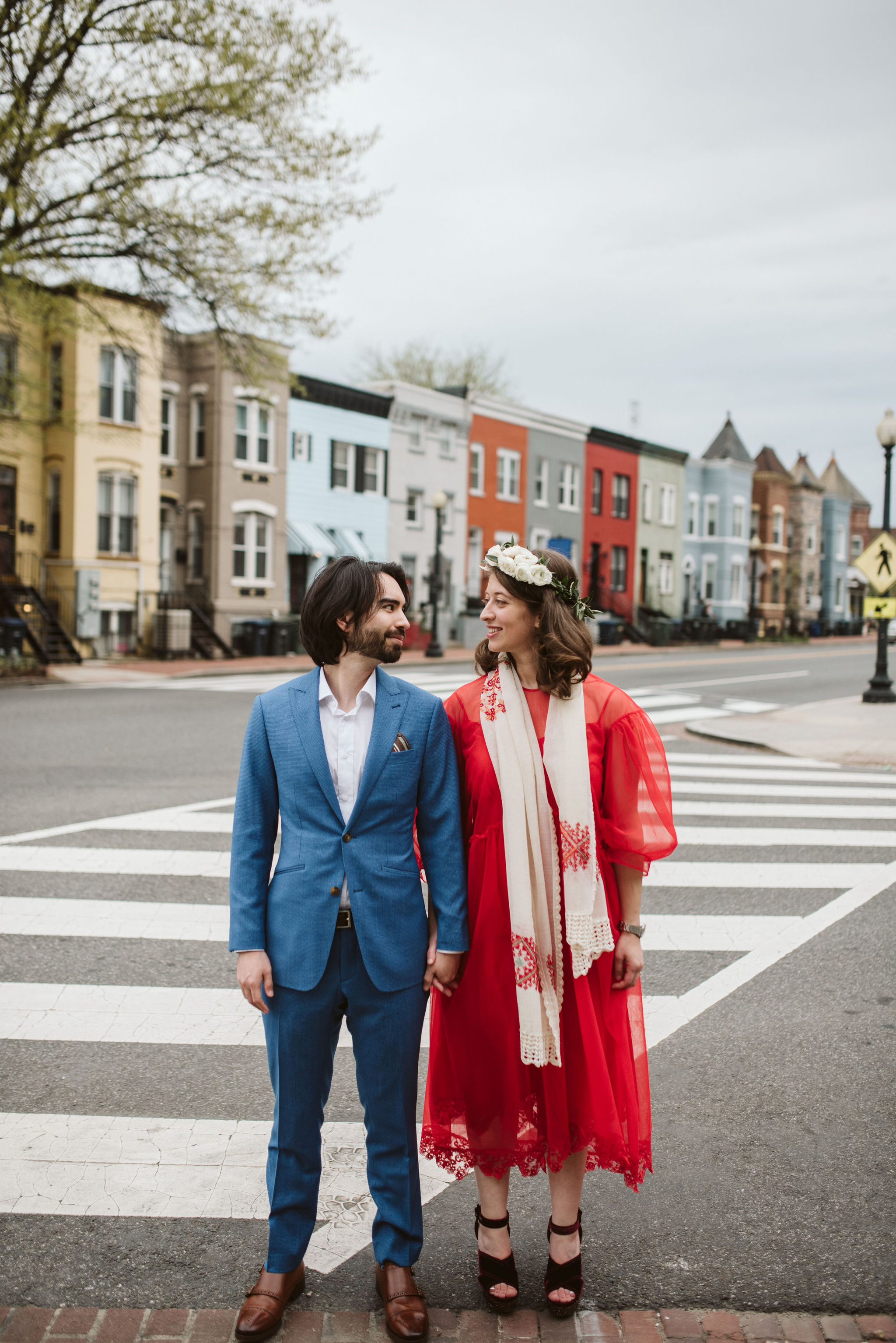  Washington DC, Baltimore Wedding Photographer, Intimate Wedding, Traditional, Classic, Palestinian, Bride and Groom Looking at Each Other on City Street, White Rose Flower Crown, Blue Suit, Red Dress 