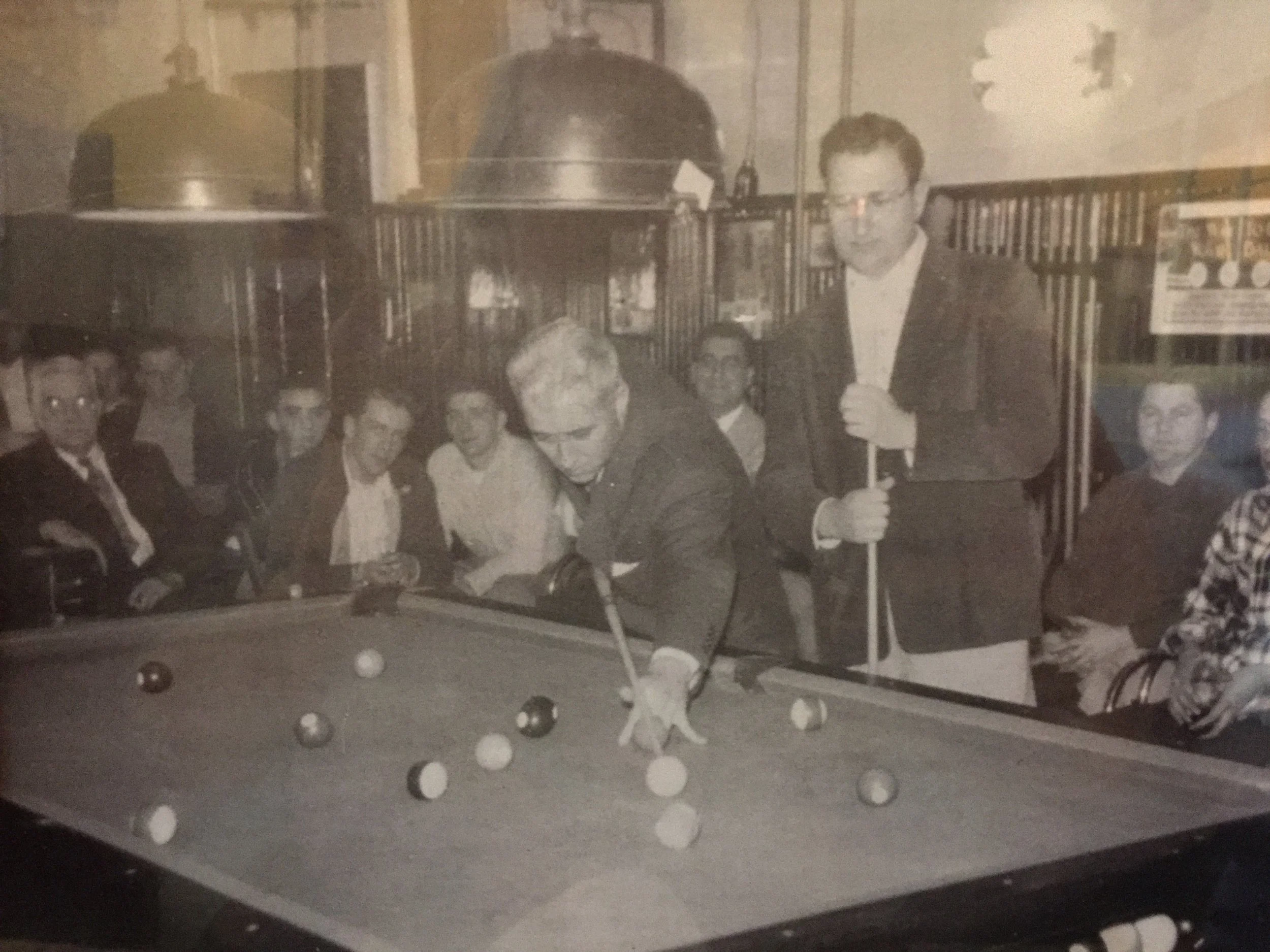 World champion Willie Mosconi takes a shot in my grandfather's pool hall as Pete Leggieri of Hudson looking on. More than 100 people watched in 1954 as Mosconi beat Leggieri in a "hard, well-played game" according to the local newspaper.