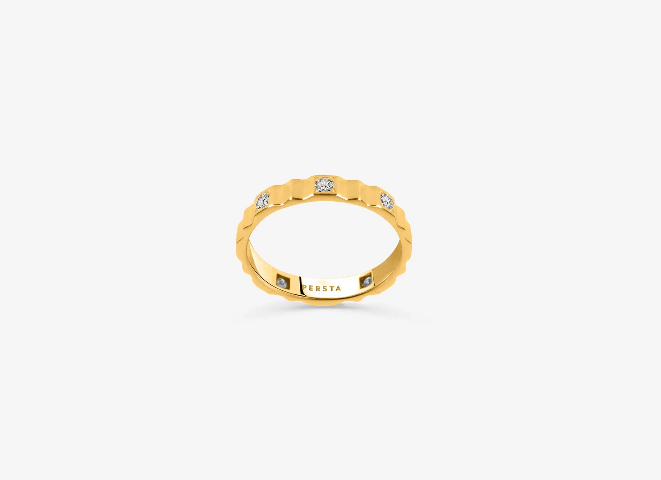 Bague en or avec diamants incrustés sur fond blanc.