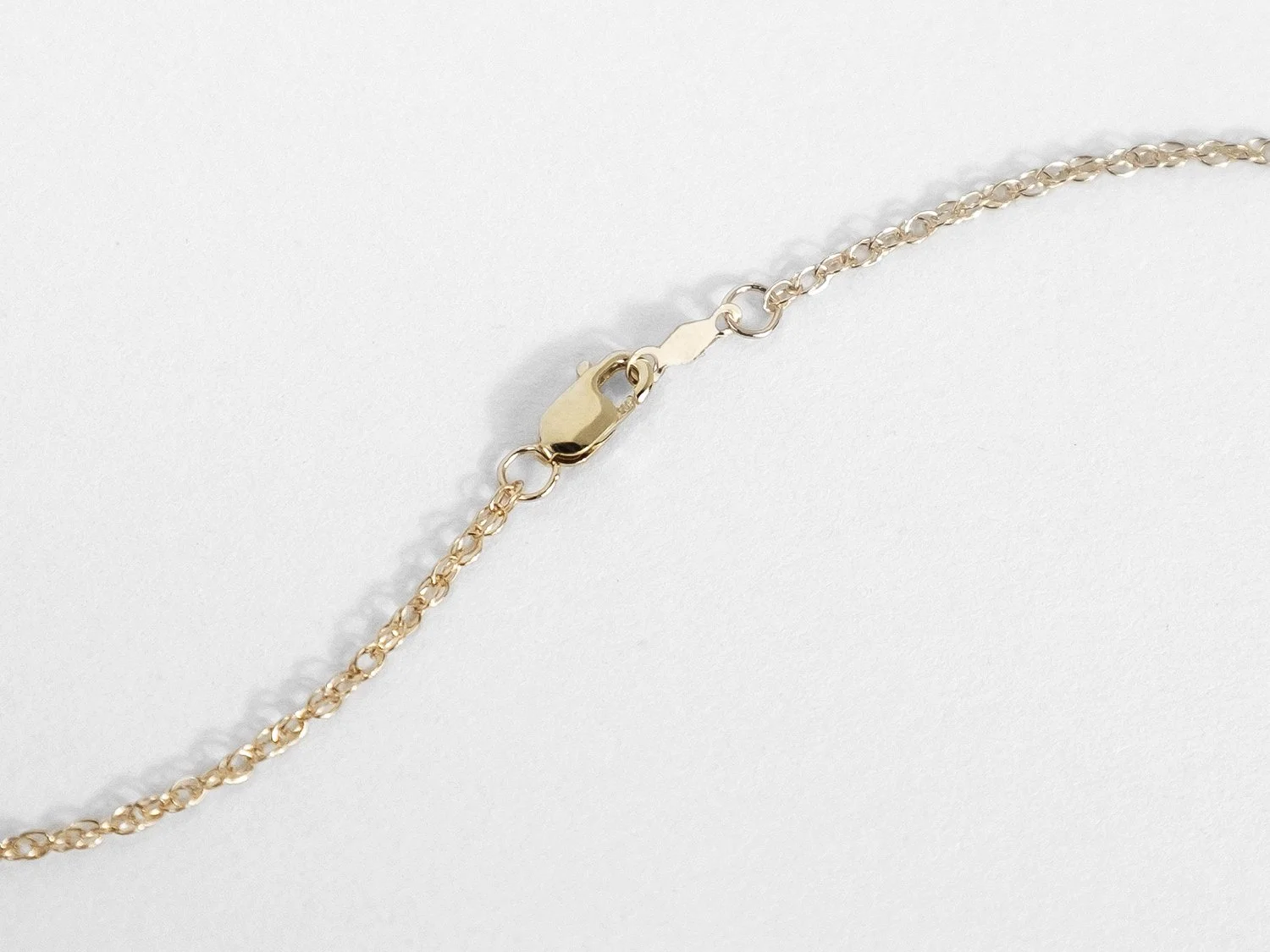 Back view of a gold chain necklace and its closure