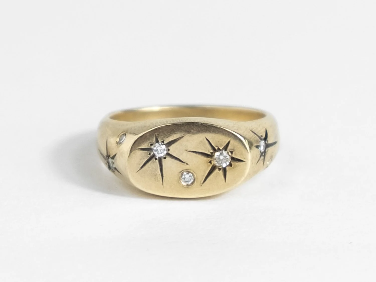 Wide gold signet ring with star-set diamonds all over the top