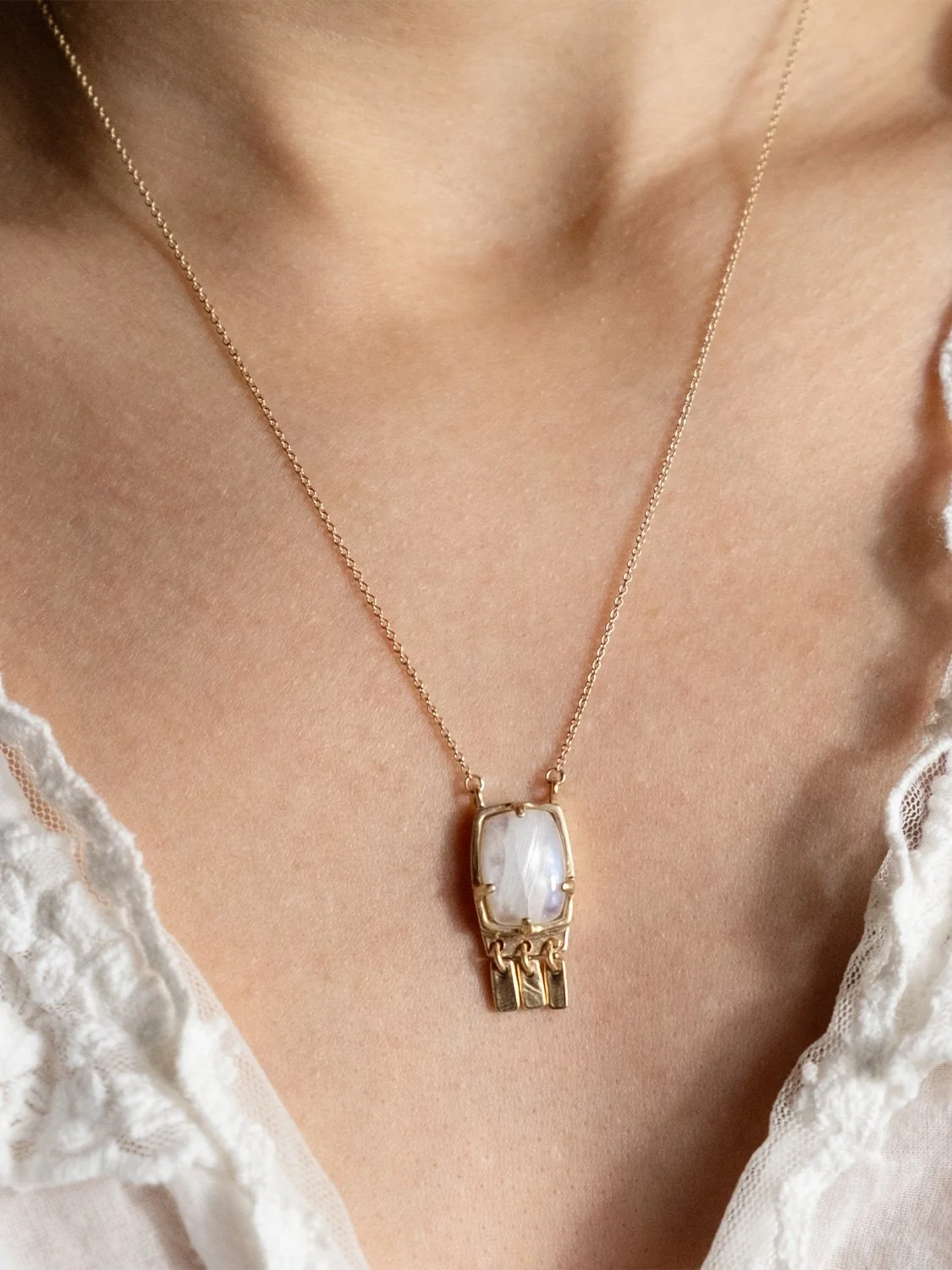 Female model wearing a 14k gold and moonstone pendant necklace
