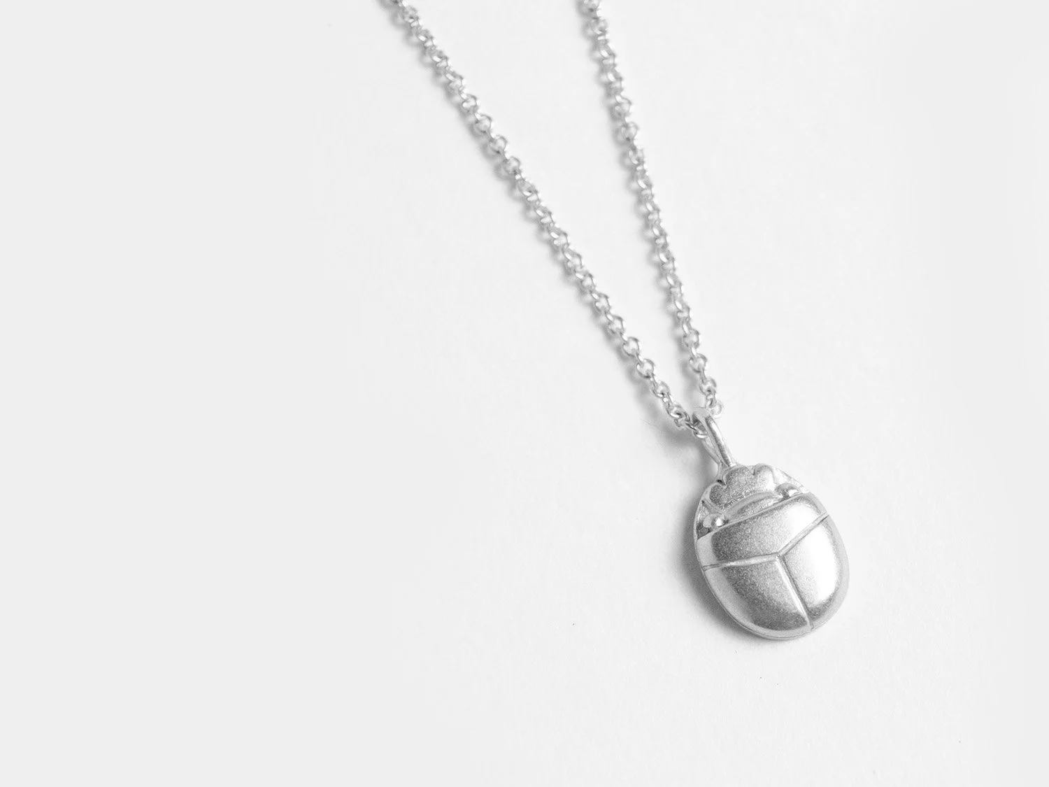 Silver pendant necklace shaped like a scarab beetle