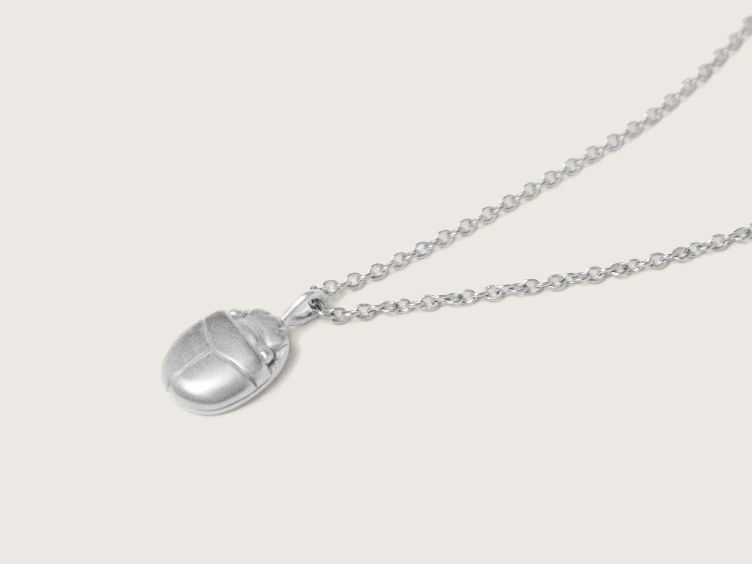 Silver pendant necklace shaped like a scarab beetle