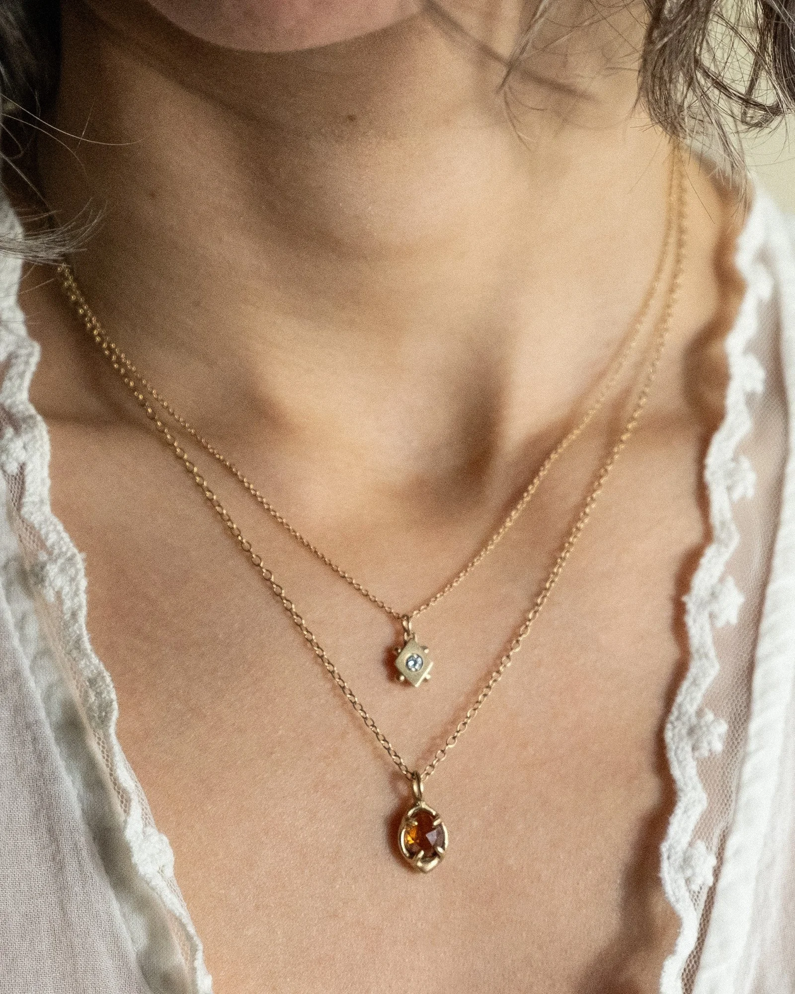 Female model wearing layered charm necklaces