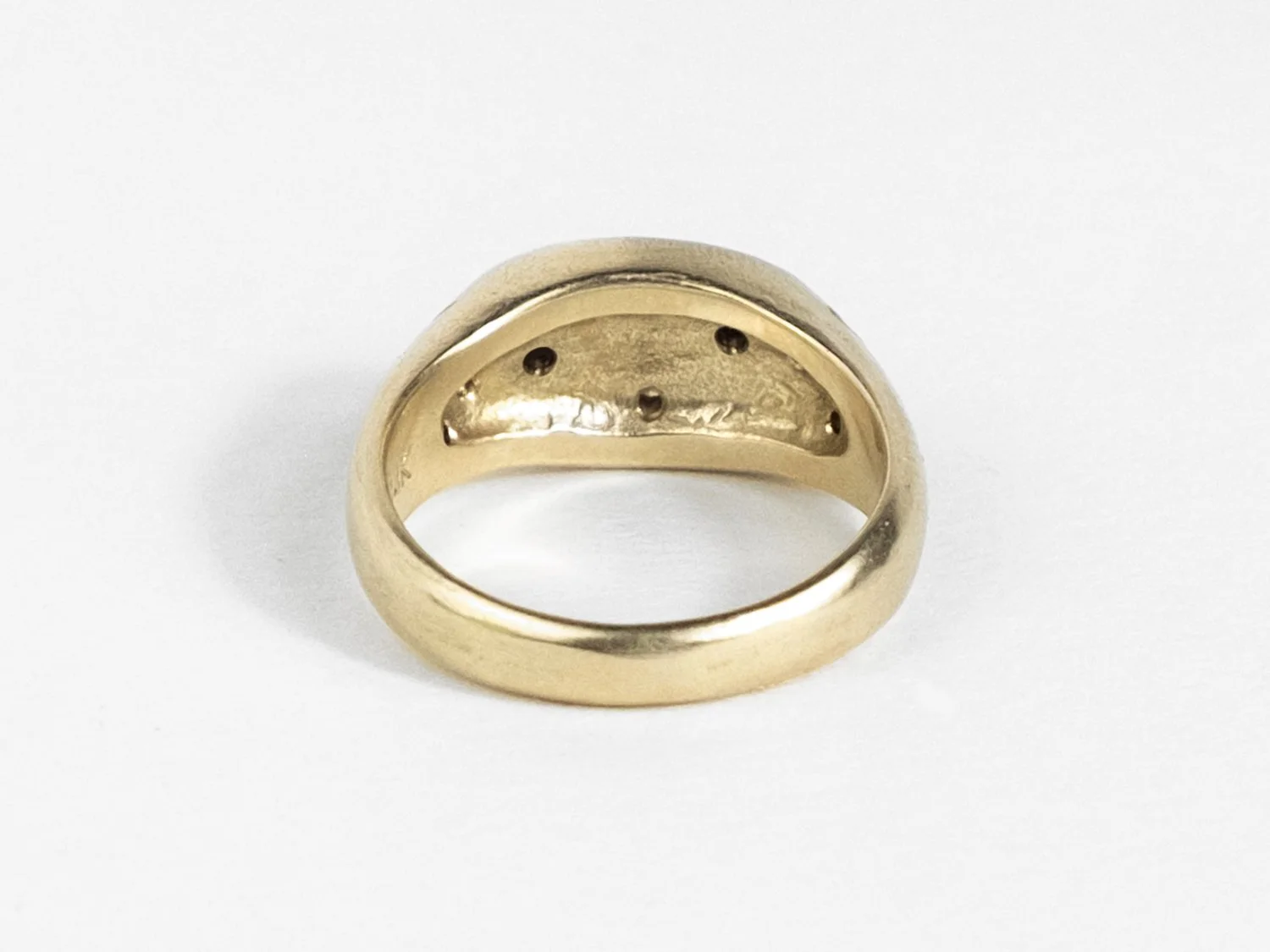 Back view of a wide gold signet ring