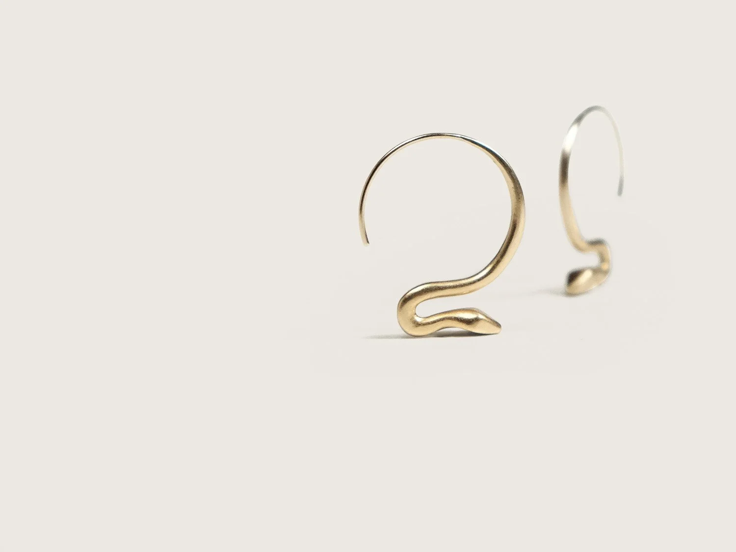 Small, gold snake-shaped hoop earrings