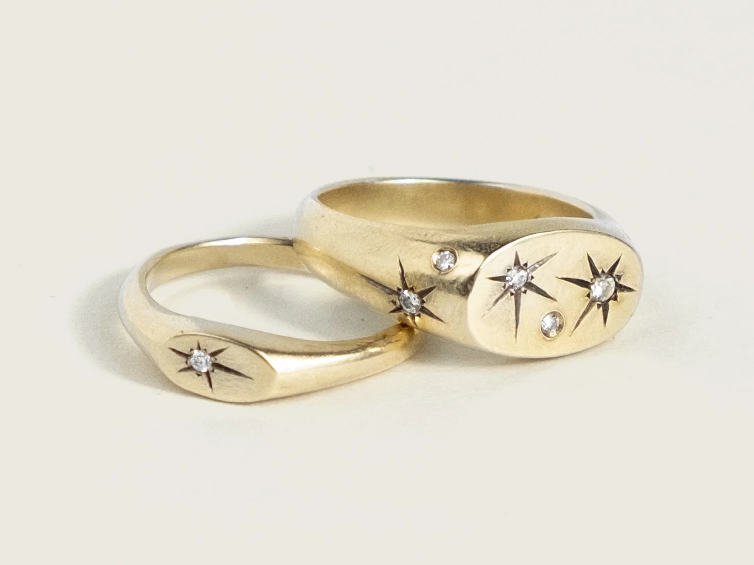 Pair of small and large signet rings covered in star-set diamonds