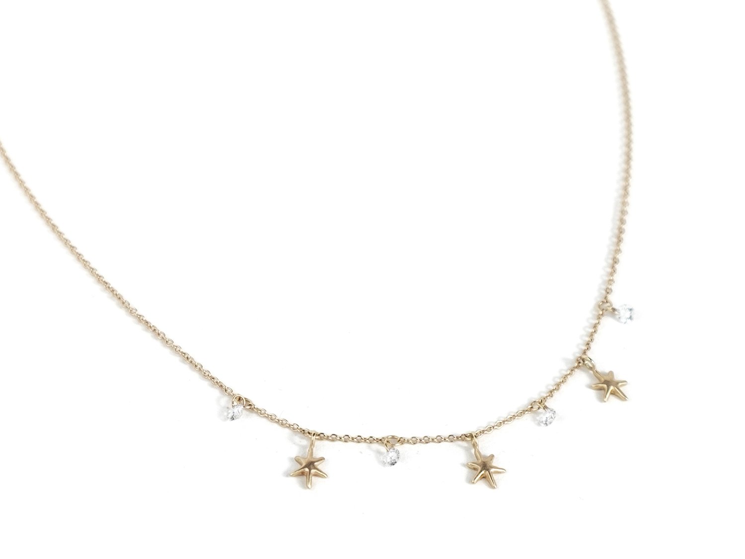 Gold necklace with hanging gold stars and white diamonds
