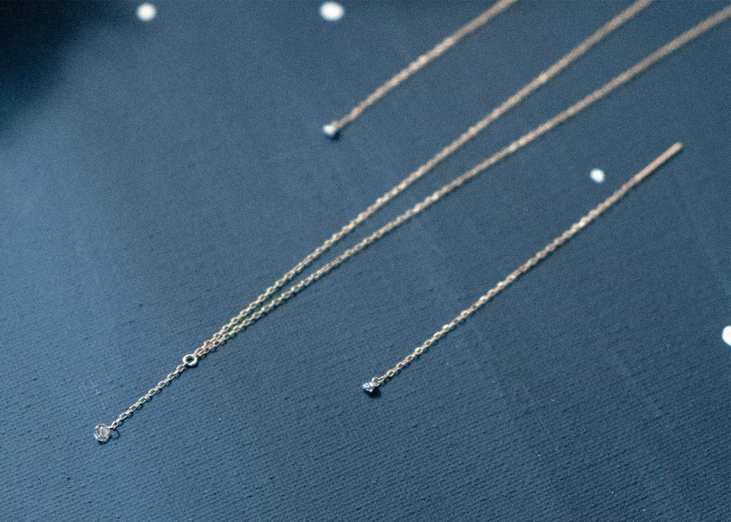 Delicate gold chain earring and necklaces with diamonds hanging from the ends