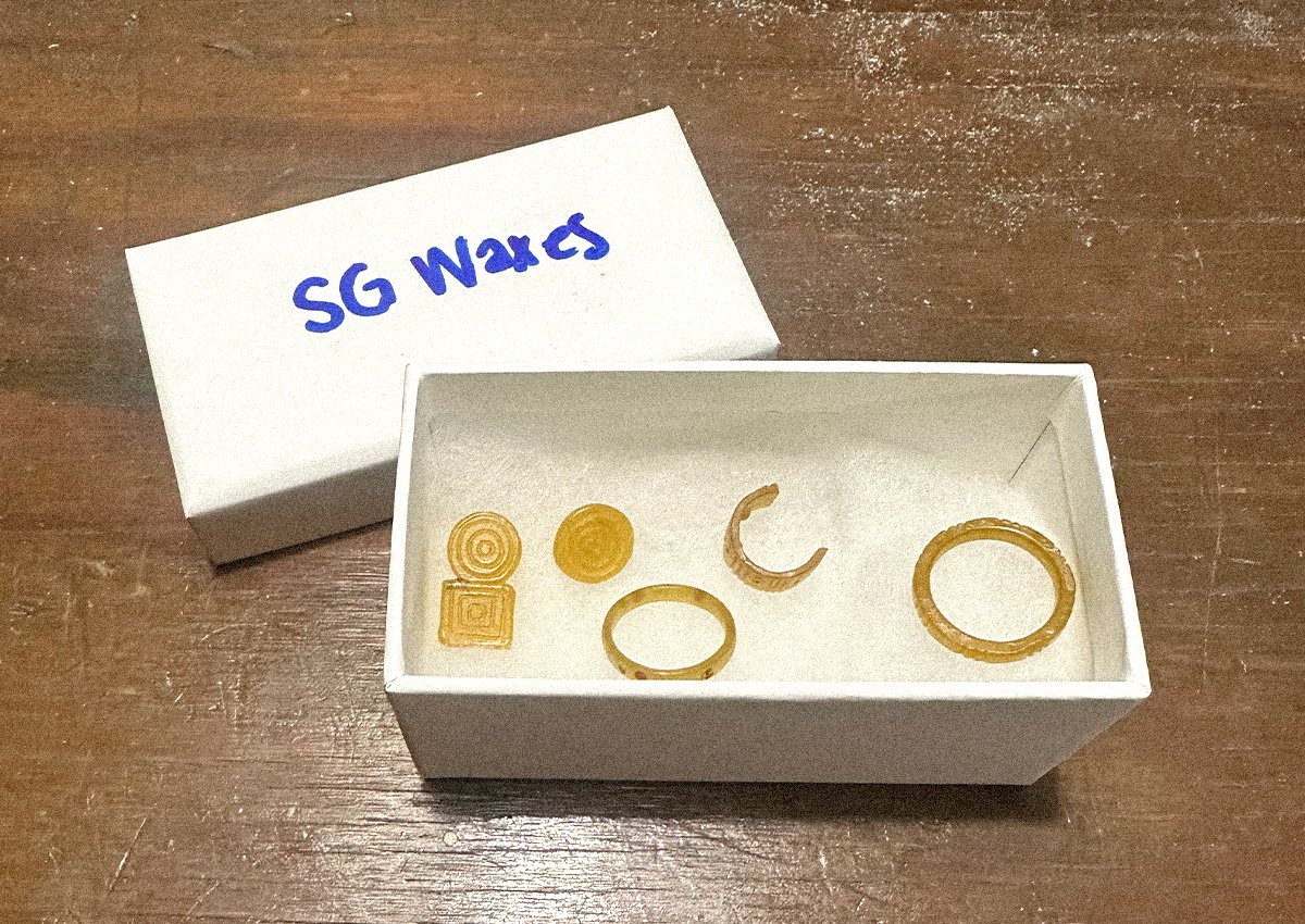 An open white box with yellow carved waxes inside
