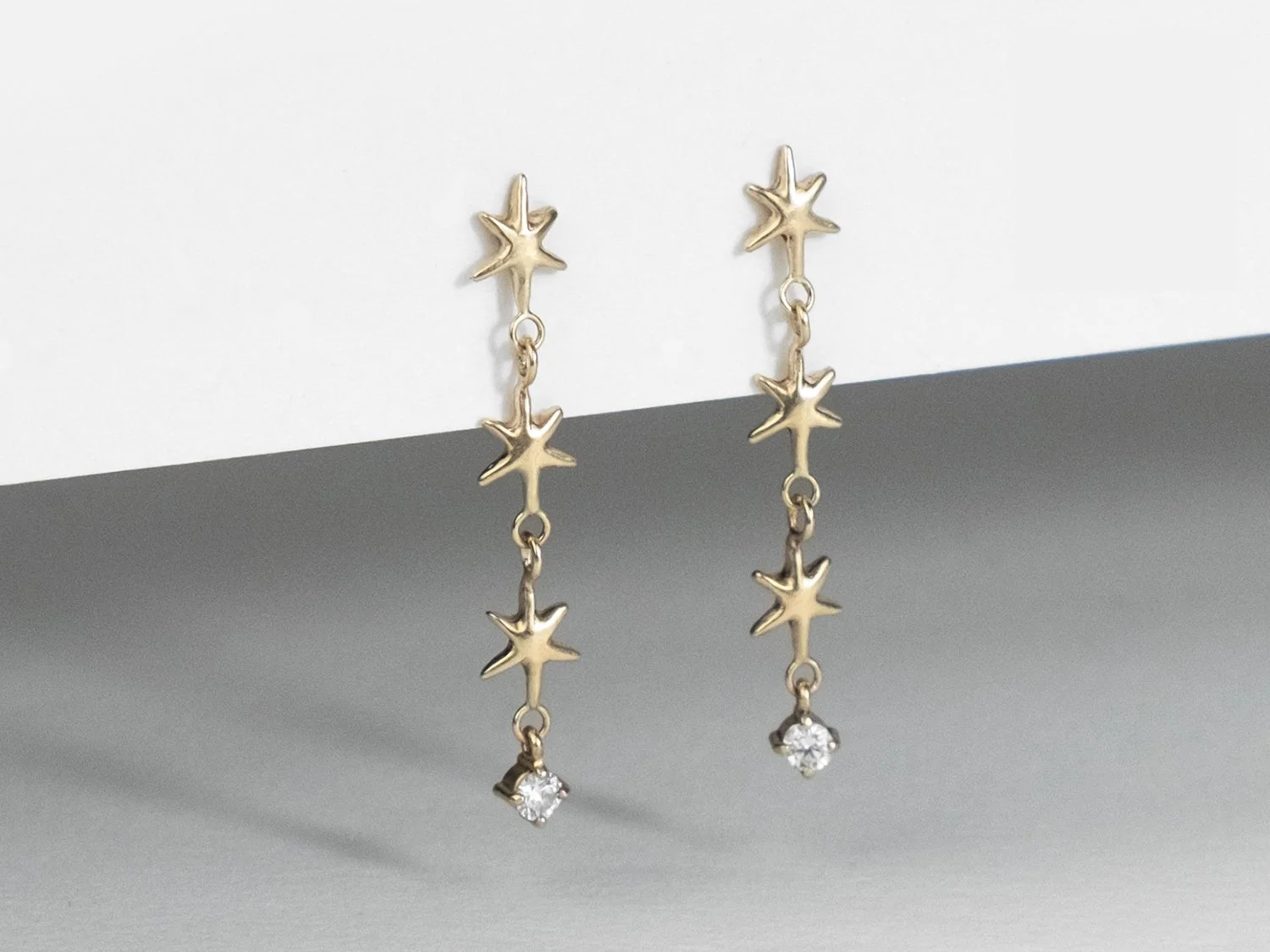 SG26_Starfall Long gold earrings made of up 3 linked stars and a hanging single diamond 3.jpg