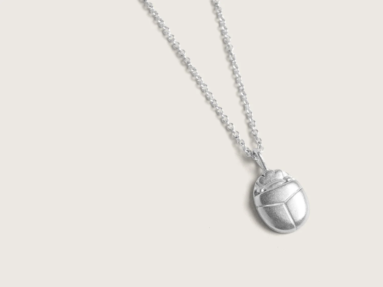Silver pendant necklace shaped like a scarab beetle