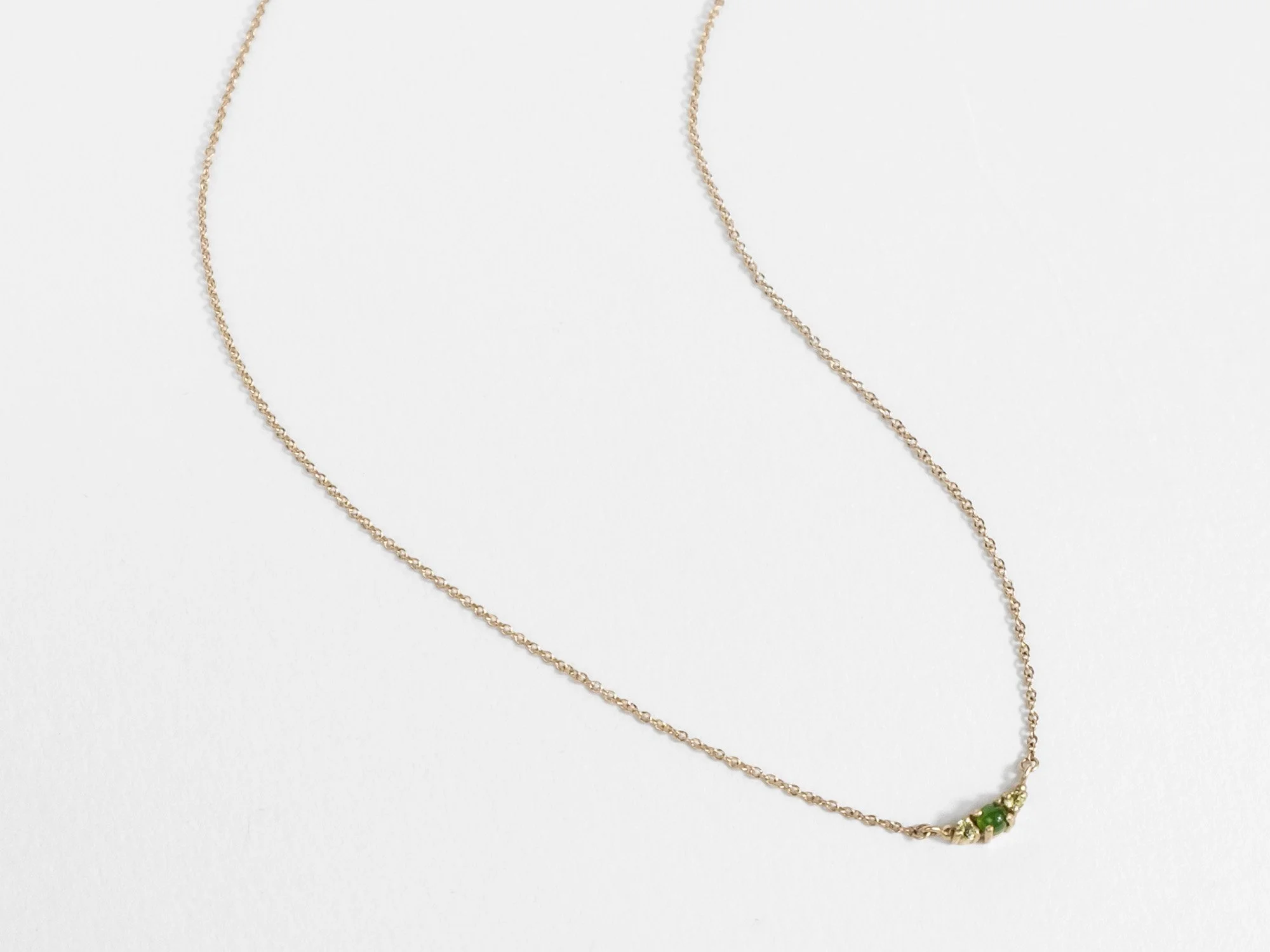 Delicate 14k gold necklace with a center pendant featuring green jade and peridot by Sara Golden Jewelry
