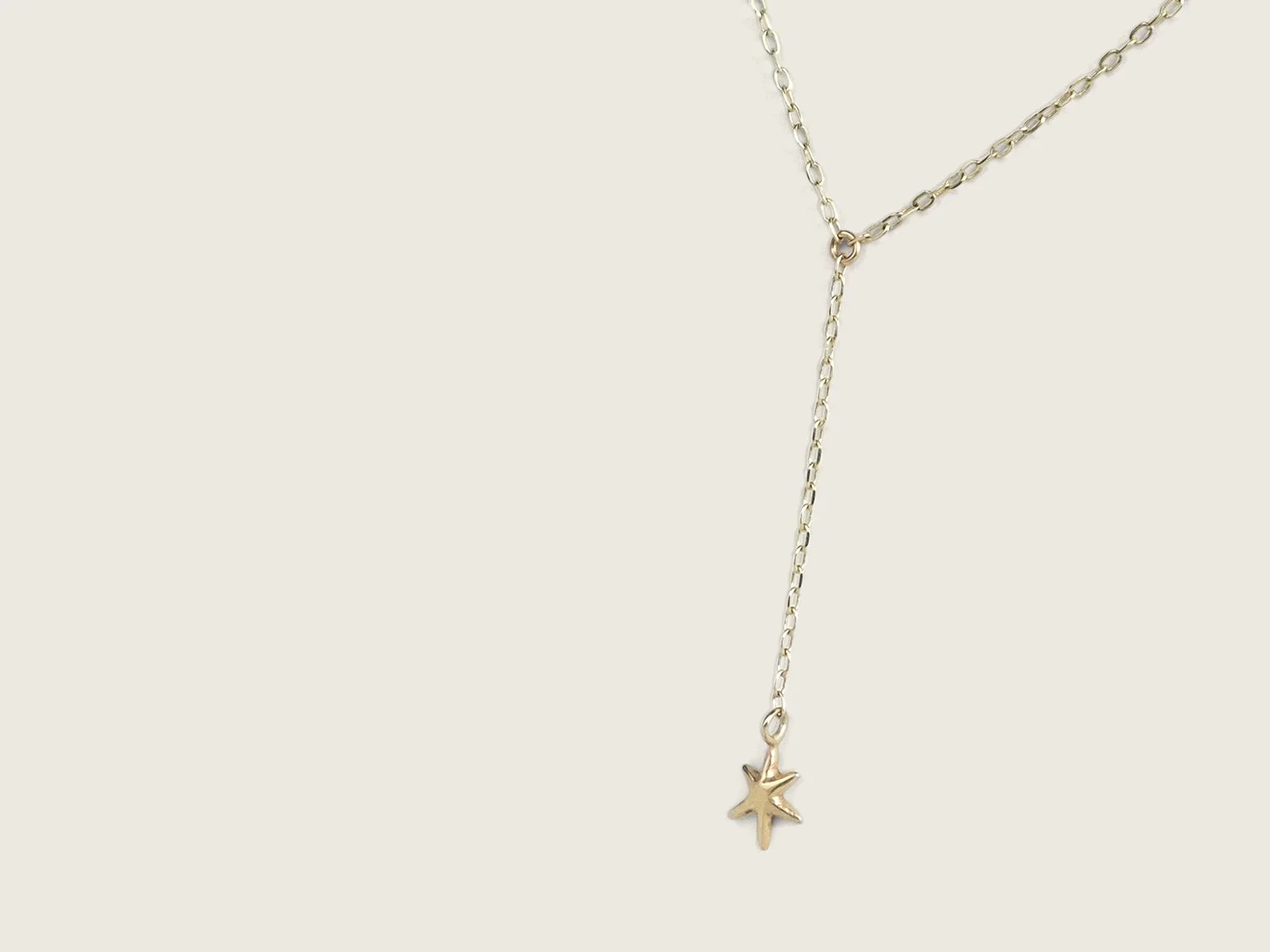 Gold lariat-style necklace with a single hanging star