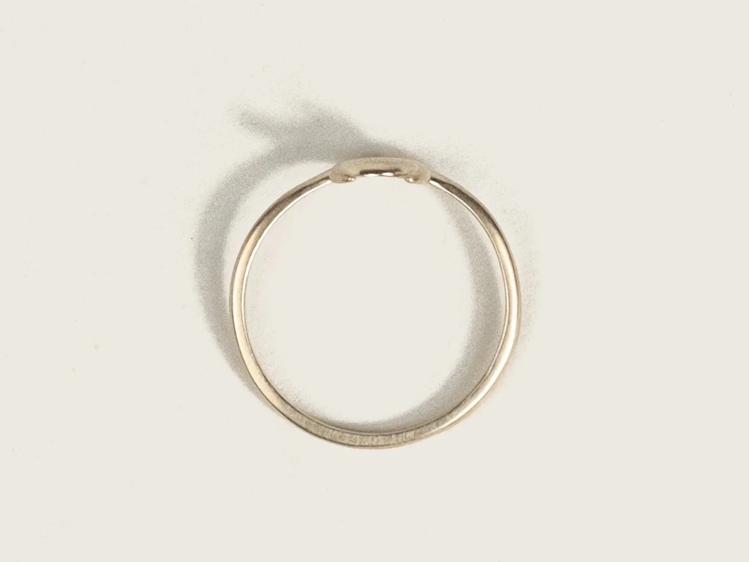 Overhead view of curved gold ring with crescent moon