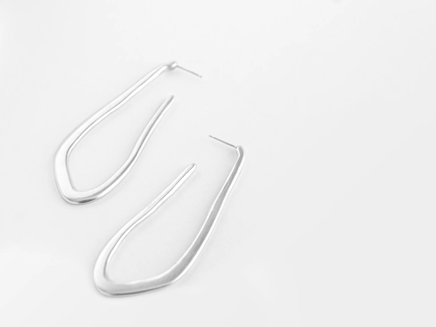 Long, wavy hoop earrings in silver by Sara Golden Jewelry