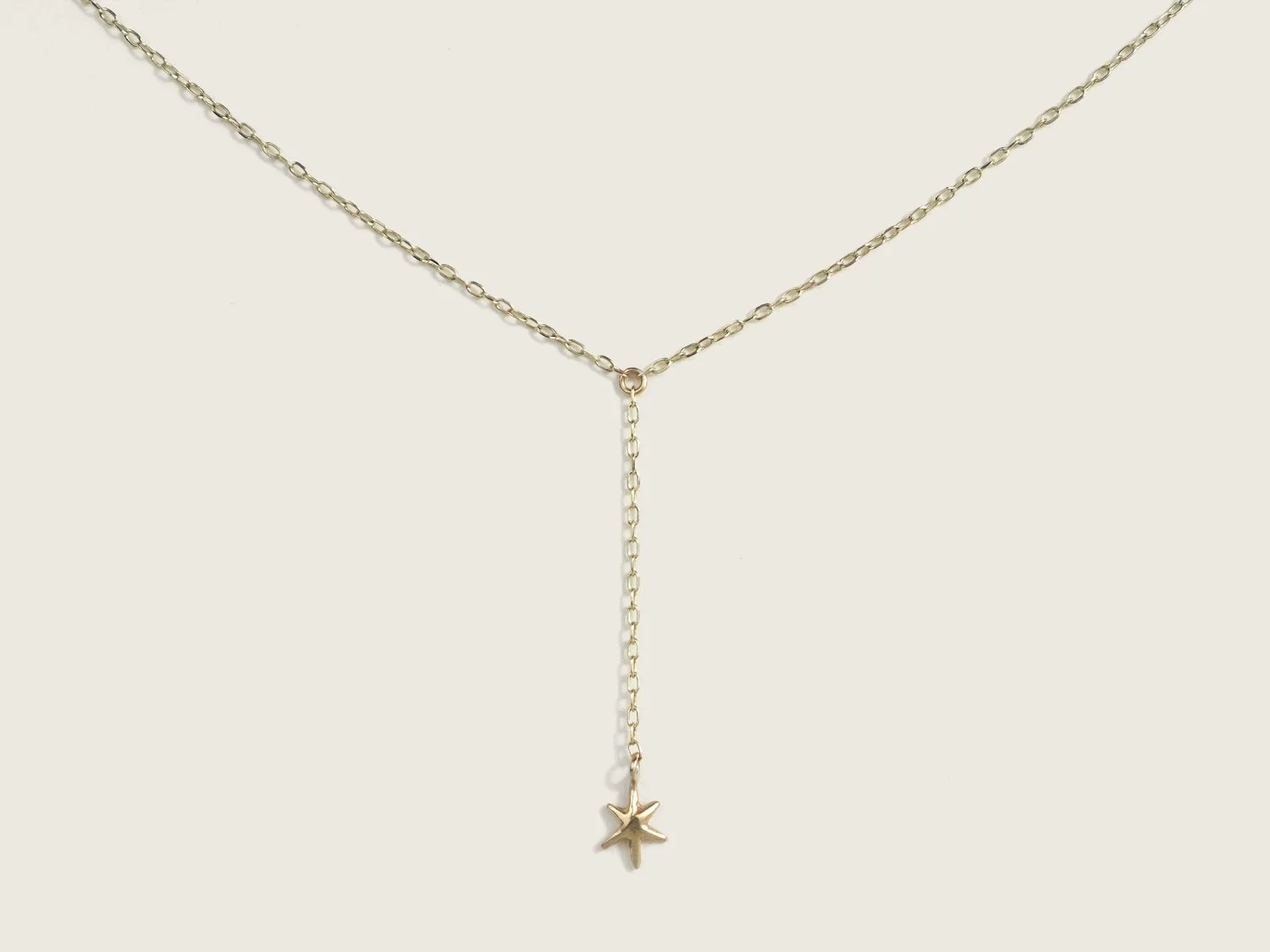 Gold lariat-style necklace with a single hanging star