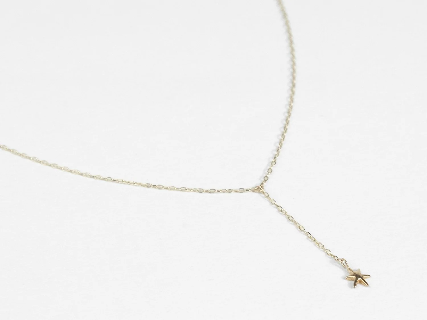 Gold lariat-style necklace with a single hanging star