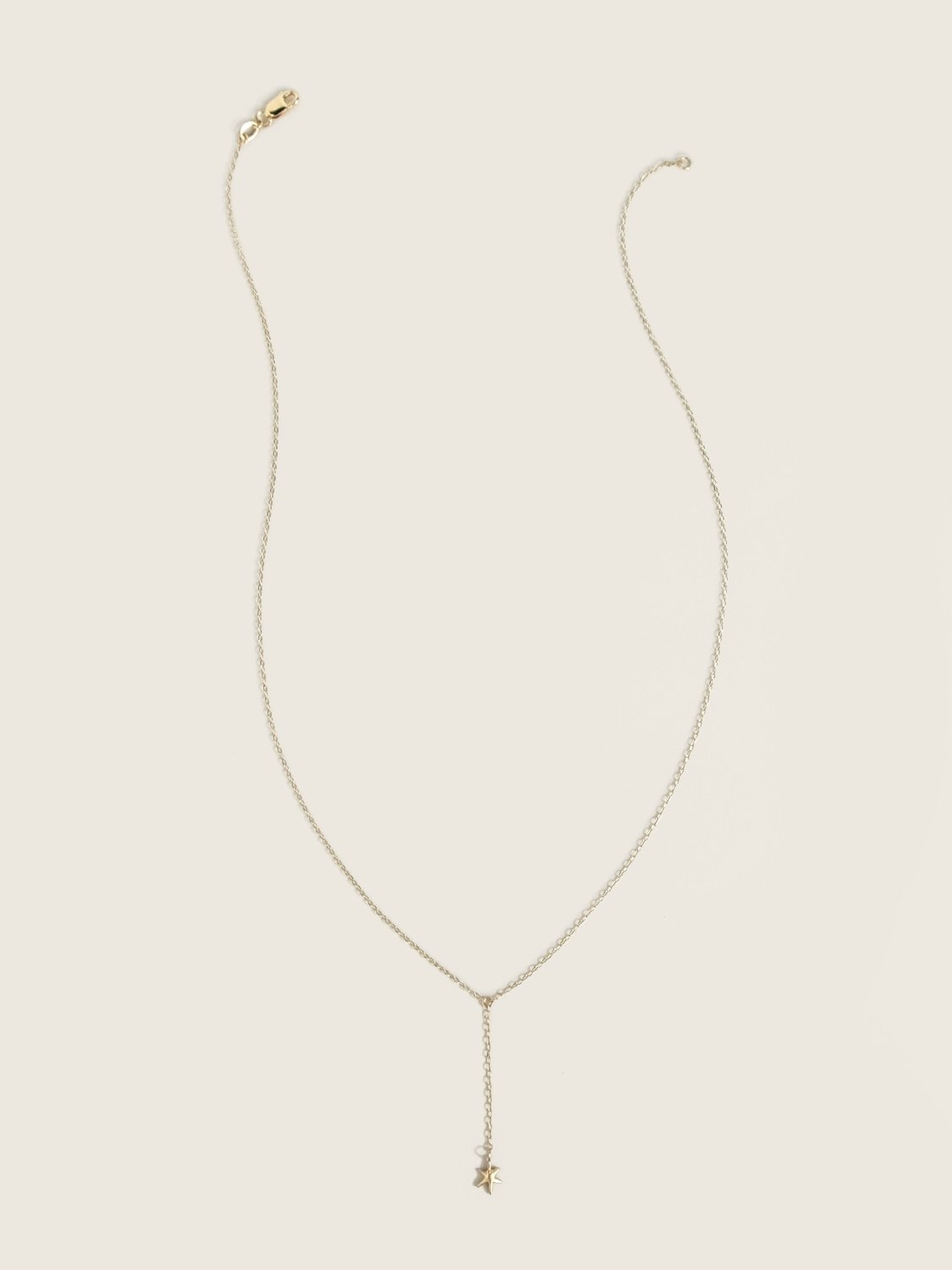 Delicate gold necklace with a small star hanging from the center