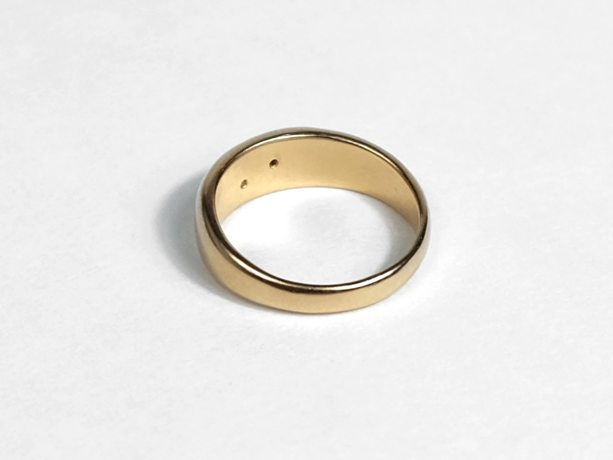 Gold tapered ring dotted with diamonds and small divet