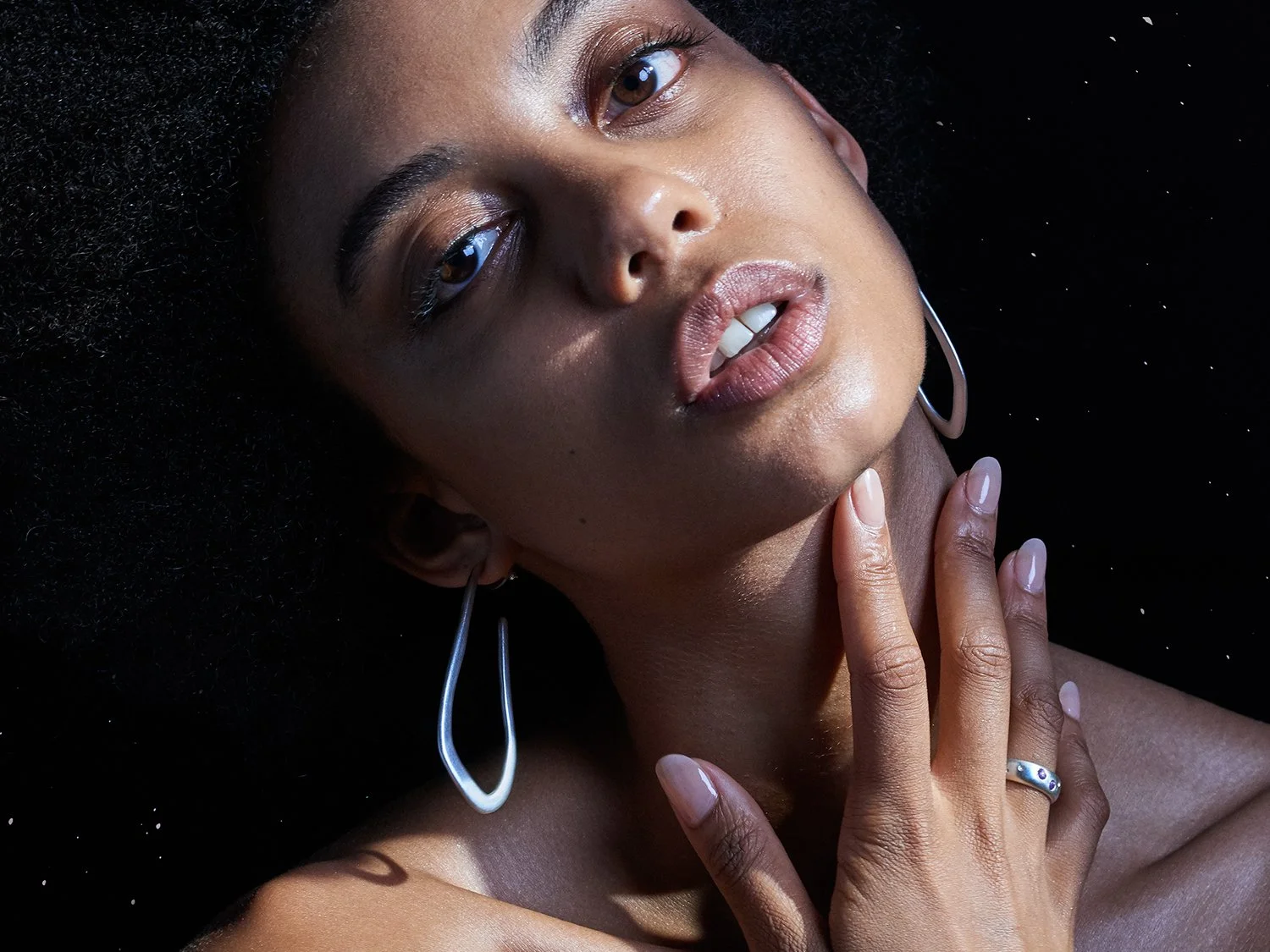 Female model wearing long, wavy hoop earrings by Sara Golden Jewelry