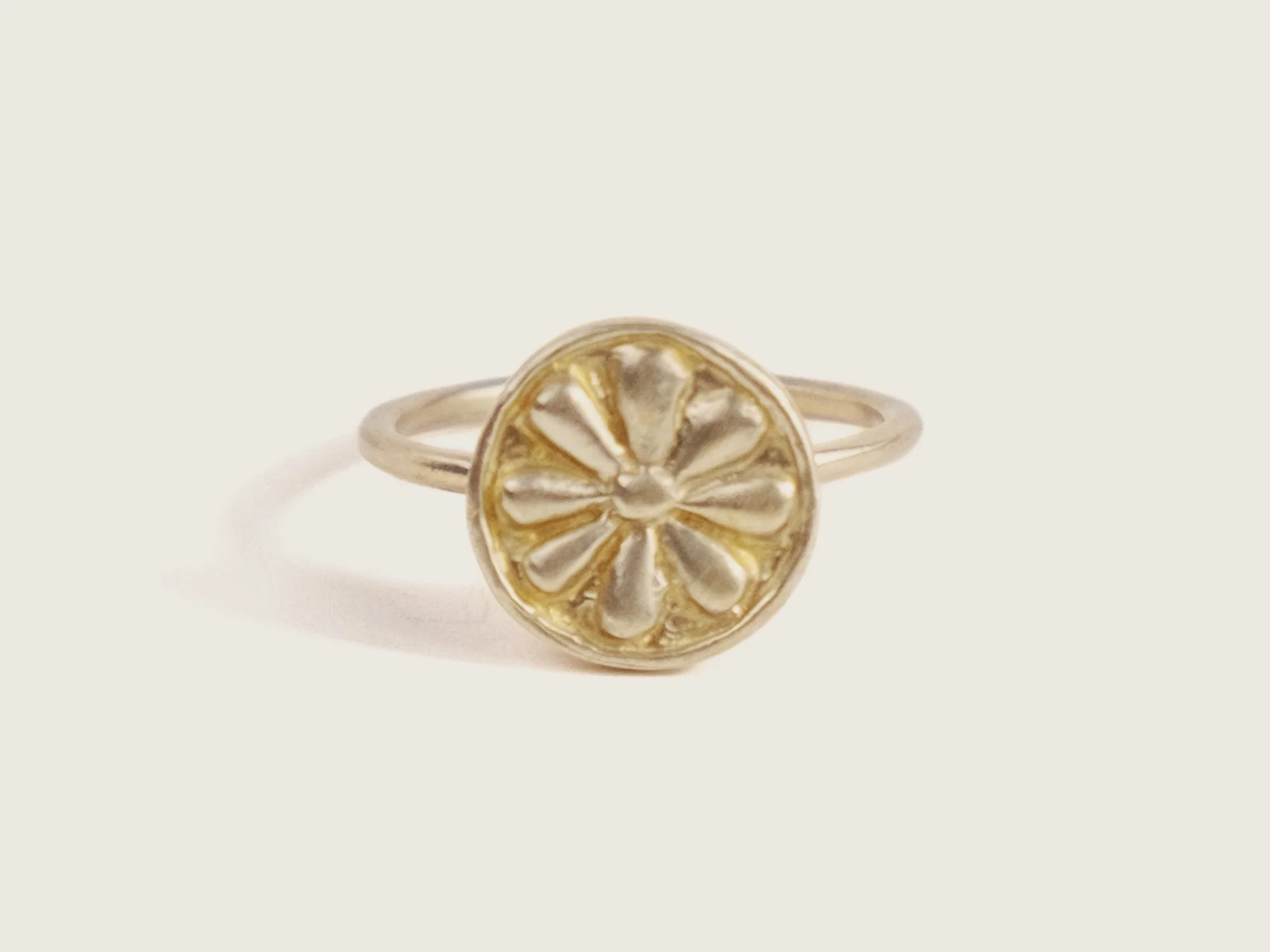 Thin gold ring with an oversized, round floral motif on top (Copy)