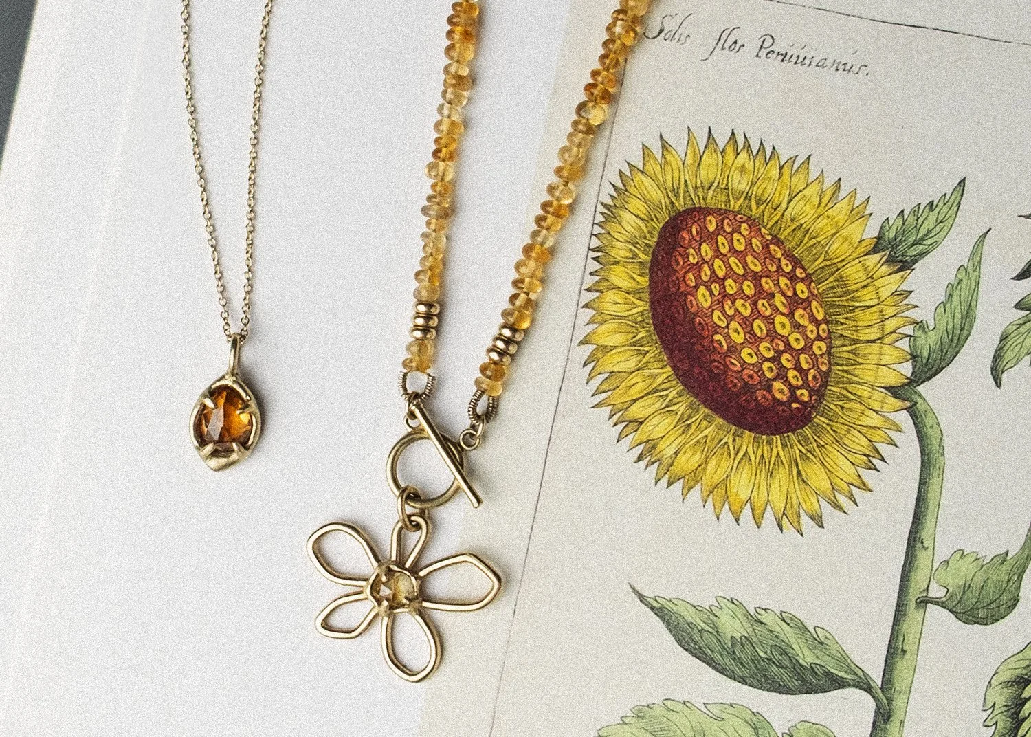 Gold necklaces with hand-cut stones on the page of an open book