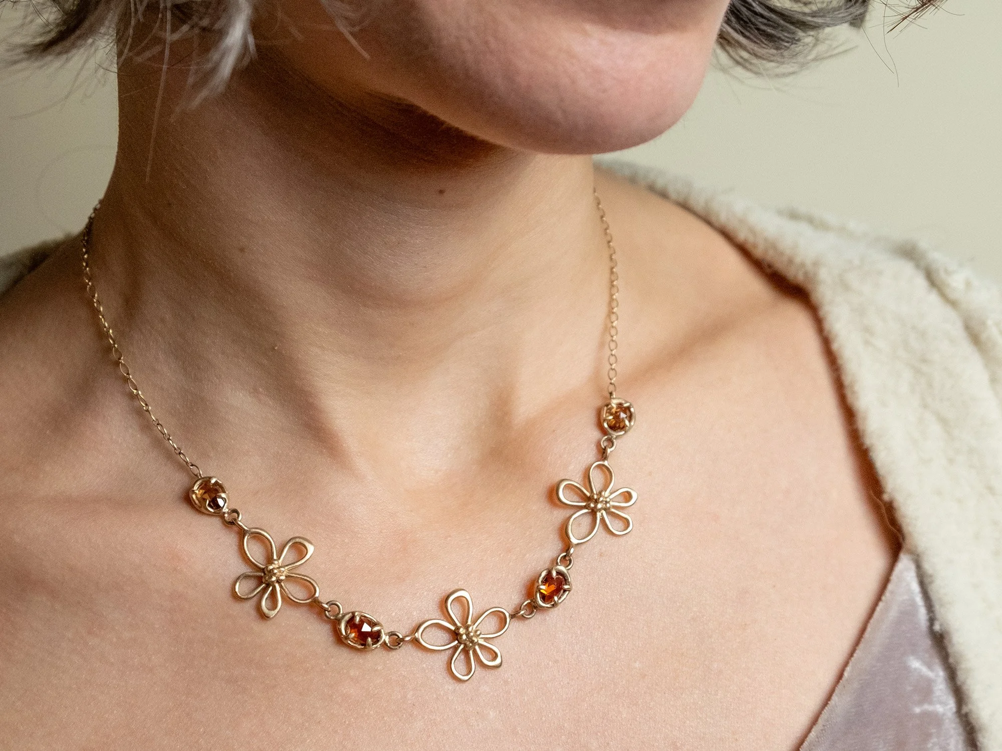 Female model wearing a floral and gemstone necklace