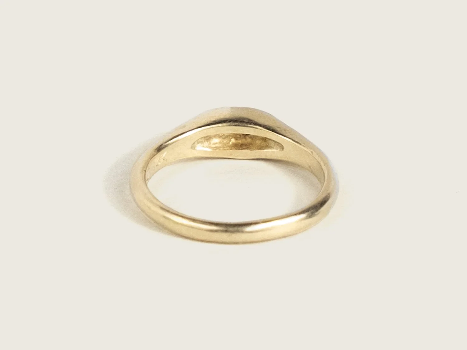 Back view of a slim gold signet ring