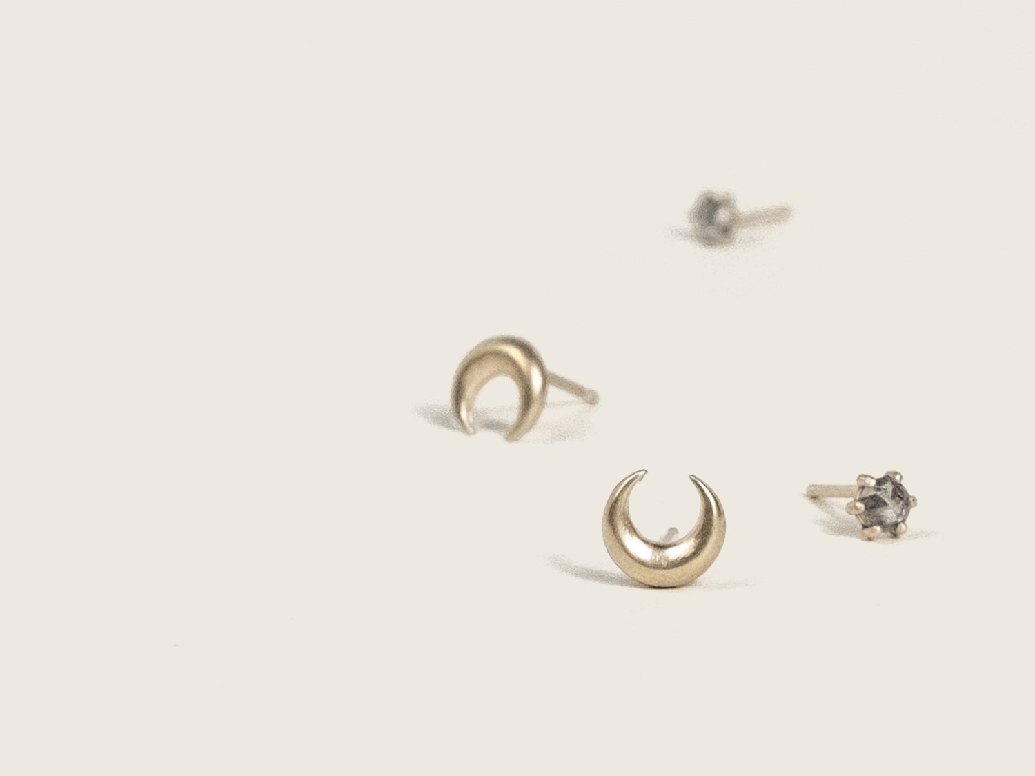 SG23_LunPair of gold crescent moon studs and salt & pepper diamond studs on a white backgrounda Studs 3.jpg
